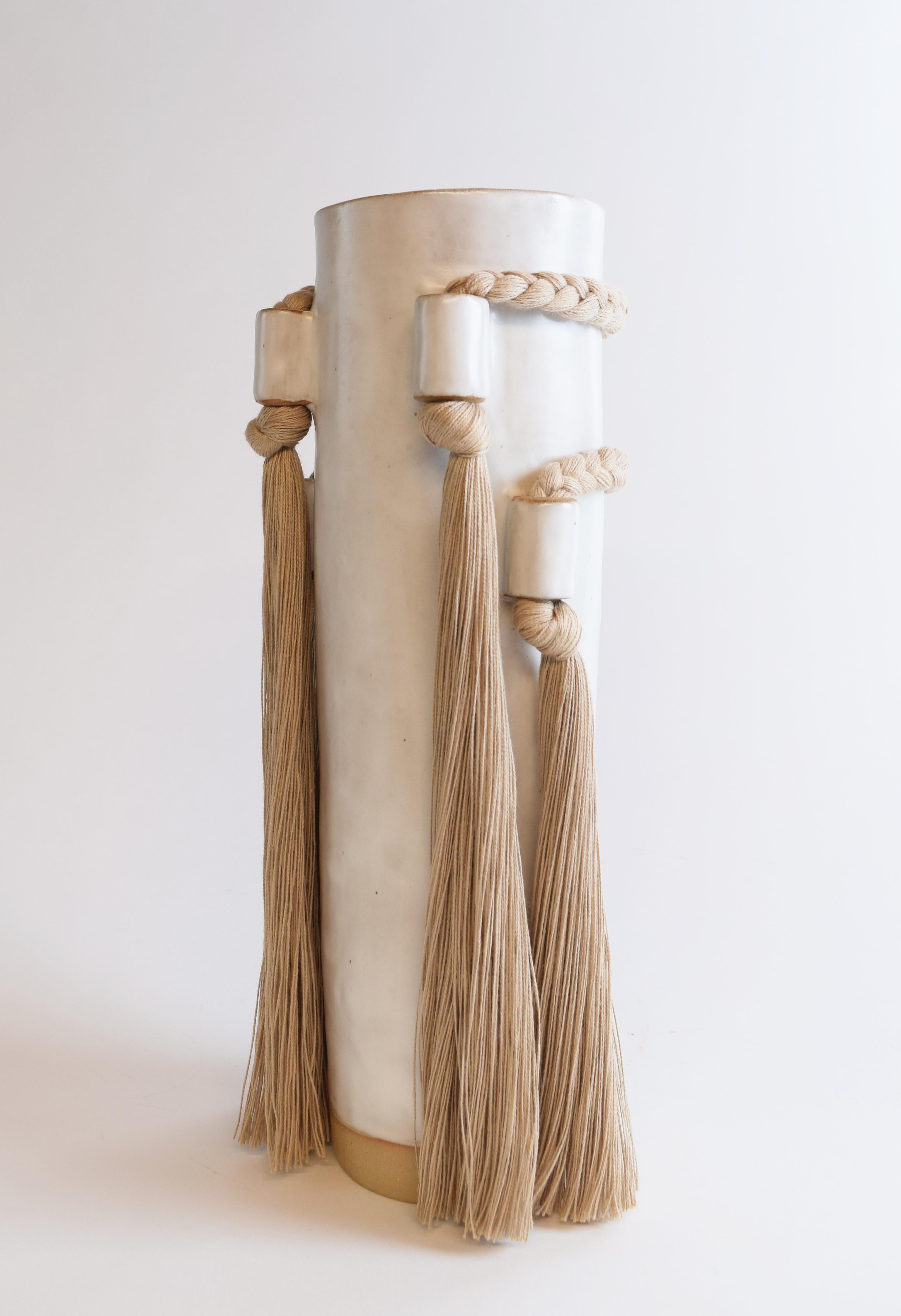 Vase #735 by Karen Gayle Tinney

Featuring fringe and braided details from all views, this vase is sized to hold a large arrangement of flowers or to stand alone as a sculptural piece.

Hand formed stoneware with white glaze. Tan cotton braided