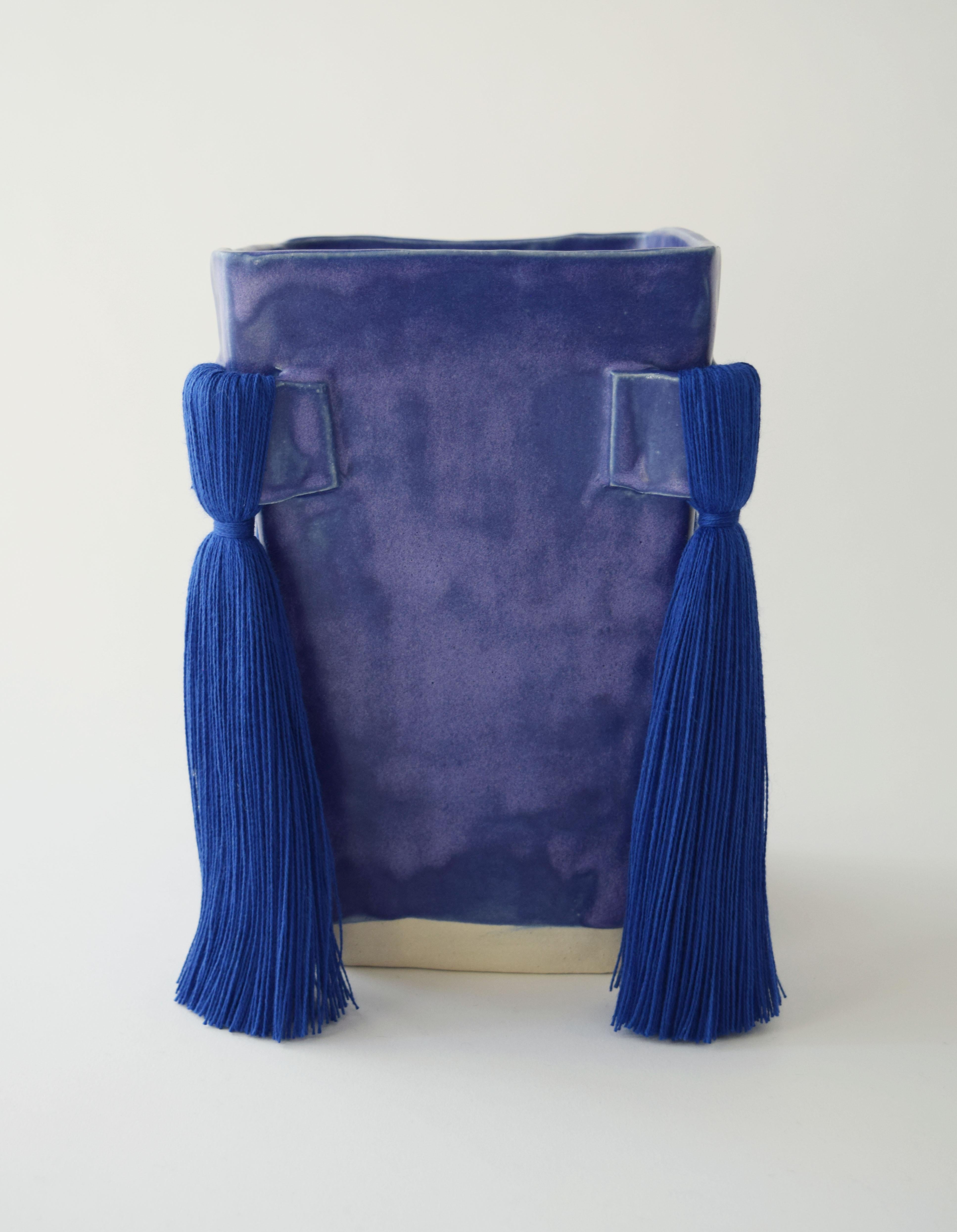 Vase #640 by Karen Gayle Tinney

Hand formed stoneware vase with satin blue glaze on outside and inside. Cobalt blue cotton fringe. Vessel will hold water but care should be taken not to damage fiber areas. Vase ships with a small comb for fringe.