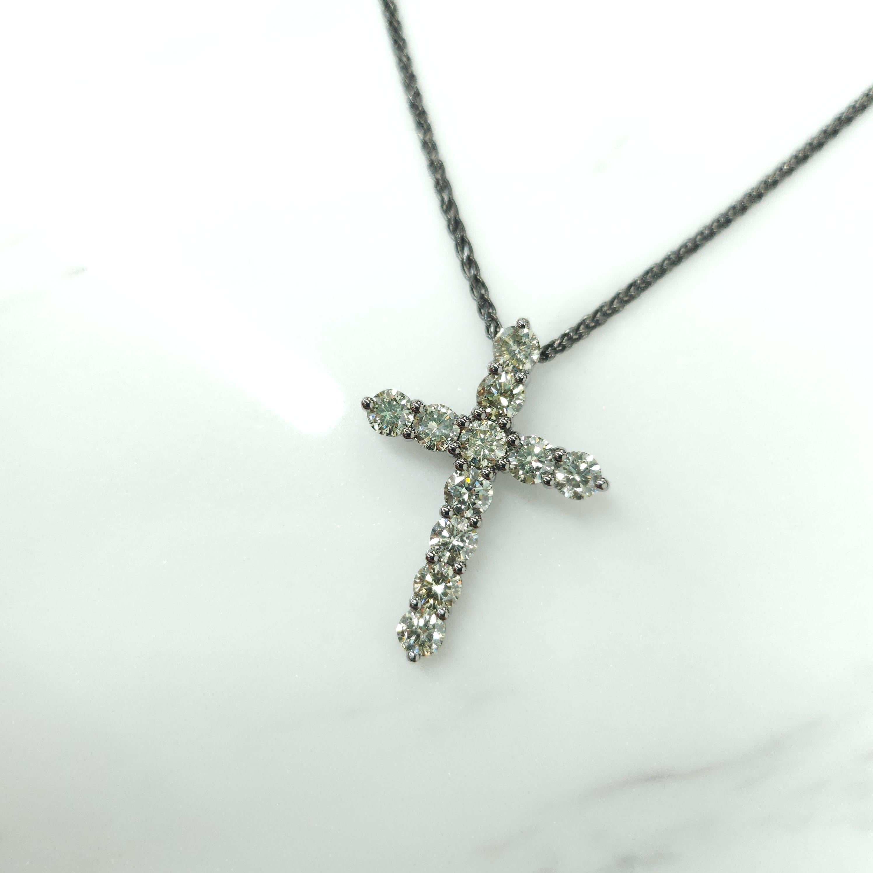 A precious interpretation of a classic motif, our cross pendant in 18K black gold is available in a variety of different carat weights, seen here with 0.22 carat diamonds. Deftly suspended from a gold chain, each diamond is embraced by a minimal