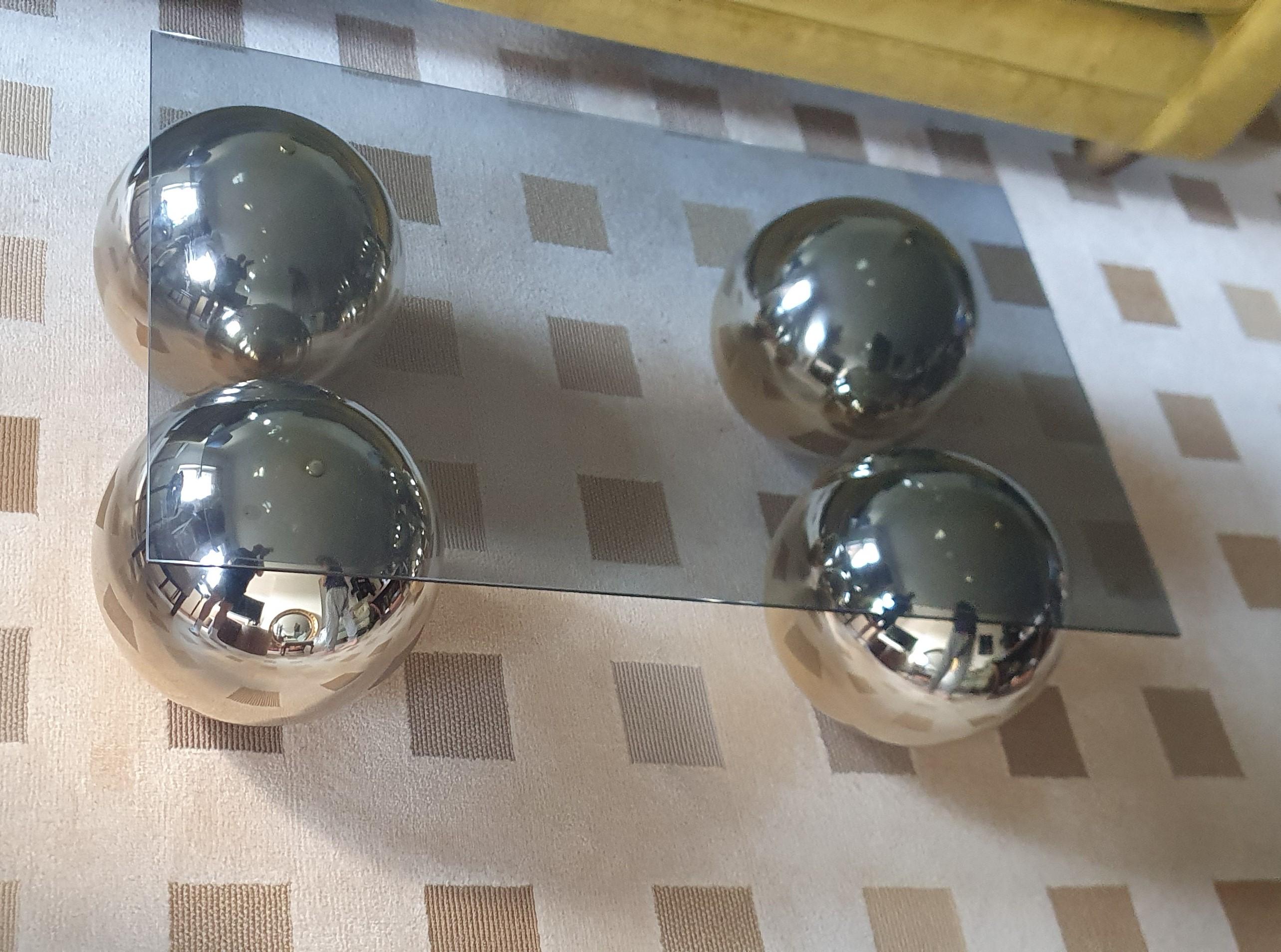 Hollywood Regency Table basse faite à la main avec 4 boules individuelles en laiton poli et plateau en verre gris en vente