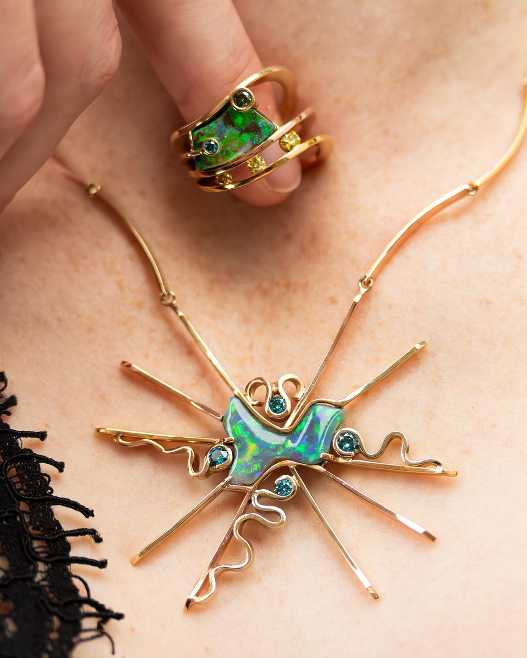 Il collier è stato creato con un opale come simbolo dell'Australia al centro di un anello di raggi. Le diverse tonalità giallo-oro dei raggi solari visualizzano il caldo torrido e costante. I diamanti blu disposti intorno all'opale vogliono