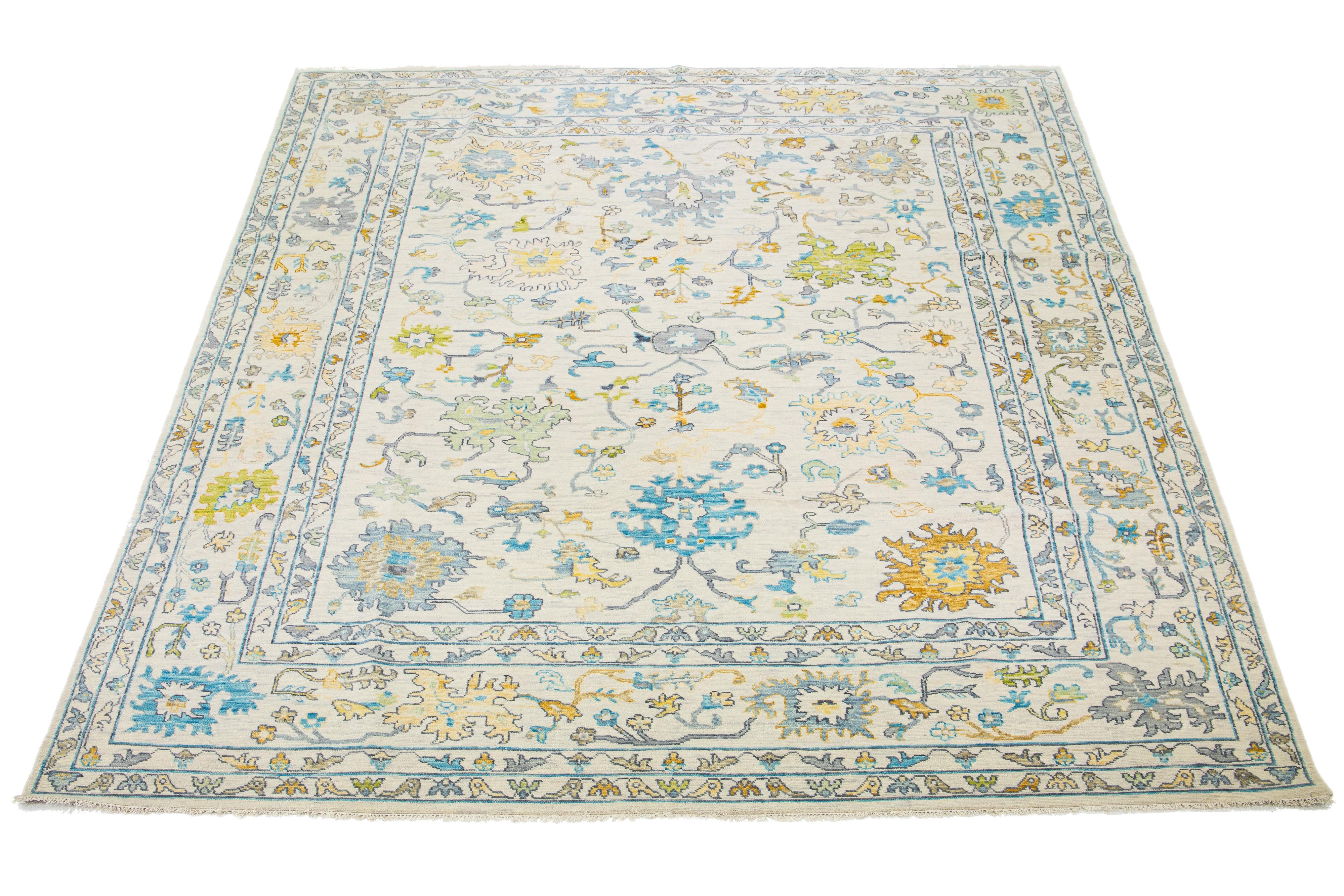 This wool rug, designed in the Oushak style, showcases a hand-knotted beige field. It exudes a contemporary aesthetic through its all-over multicolored floral design.

This rug measures 12'3