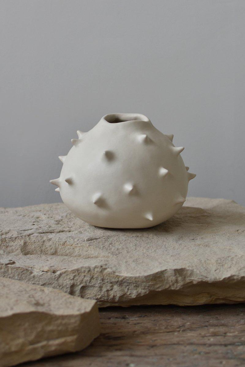 Beautiful white round ceramic vase, perfect for displaying your favorite flower arrangements. Offering a unique view from every angle, this round ceramic vase crosses the line between functionality and ornament. Use it as a fully functional flower