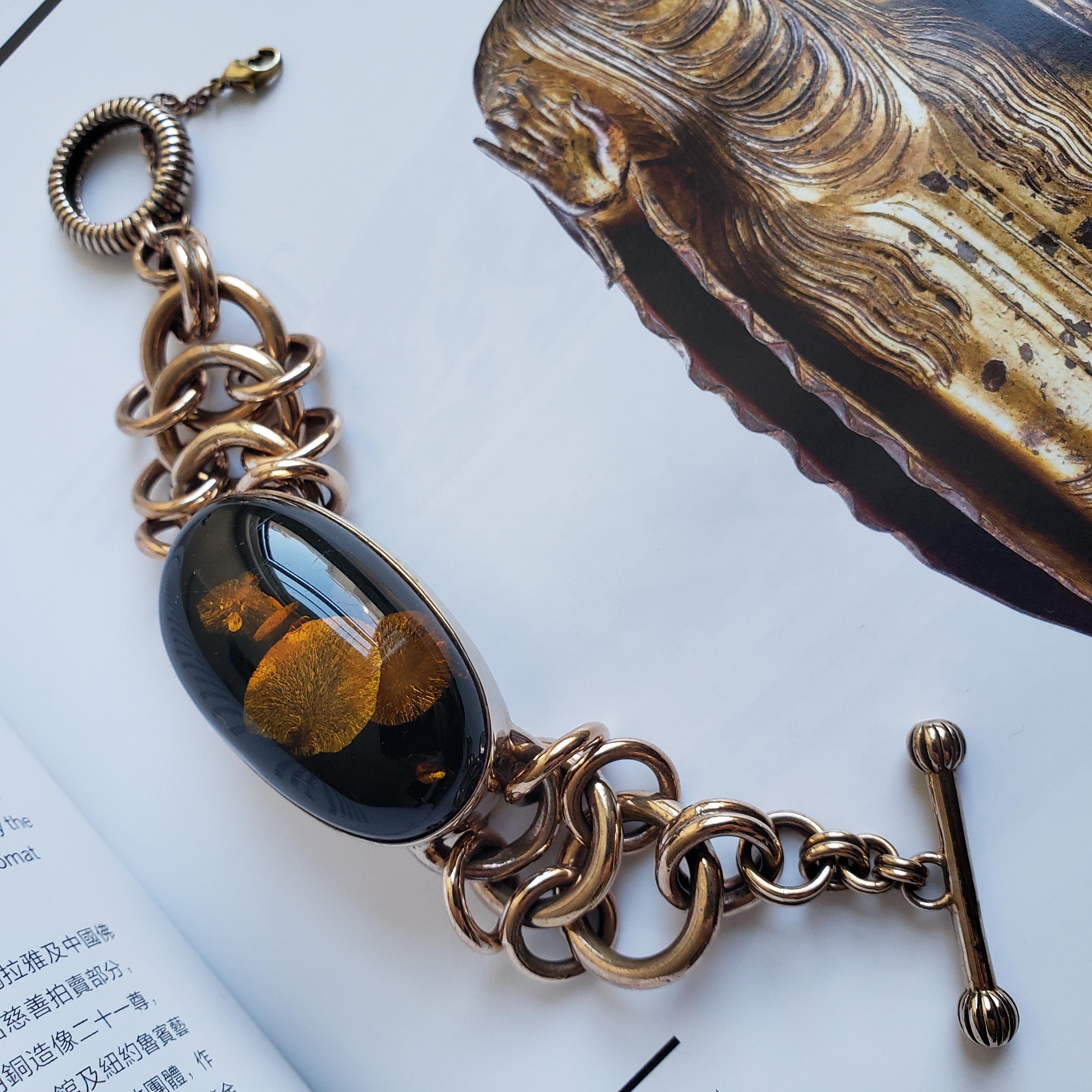 This singular handmade bangle evokes both tactile warmth and architectural finesse. Crafted in copper with an expressive interplay of small and larger rings, the interlocked chain forms a rhythm that feels both ancient and intuitively modern.

At