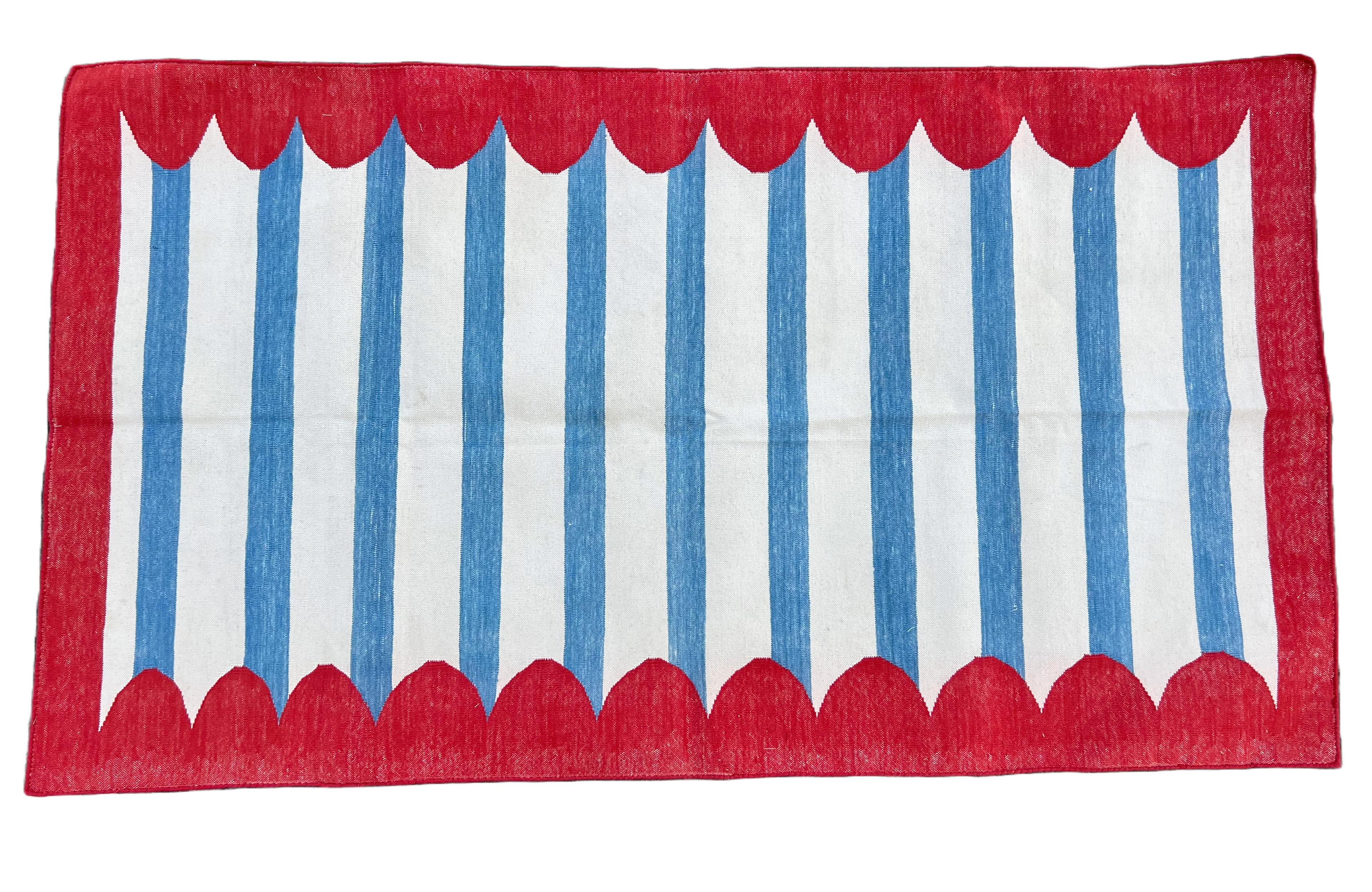 Cotton Vegetable Dyed Sky Blue And White Red Border Scalloped Striped Indian Dhurrie Rug-3'x5' (90x150cm) 

These special flat-weave dhurries are hand-woven with 15 ply 100% cotton yarn. Due to the special manufacturing techniques used to create our