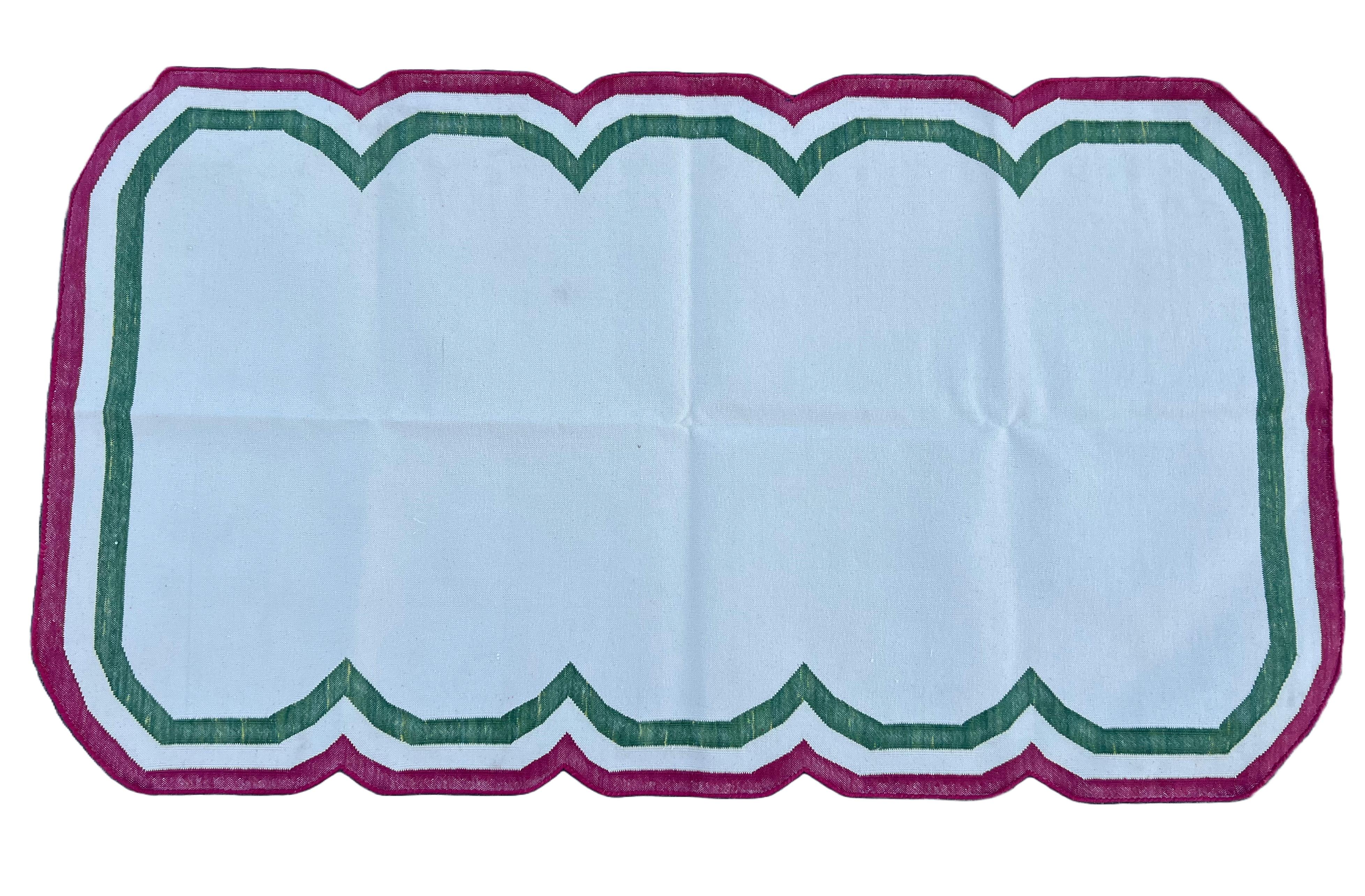 Tappeto indiano Dhurrie 3'x5' (90x150cm) in cotone tinto al vegetale con bordi a strisce smerlate color crema, verde e lampone. 

Queste speciali dhurry a trama piatta sono tessute a mano con un filo di cotone 100% a 15 strati. A causa delle
