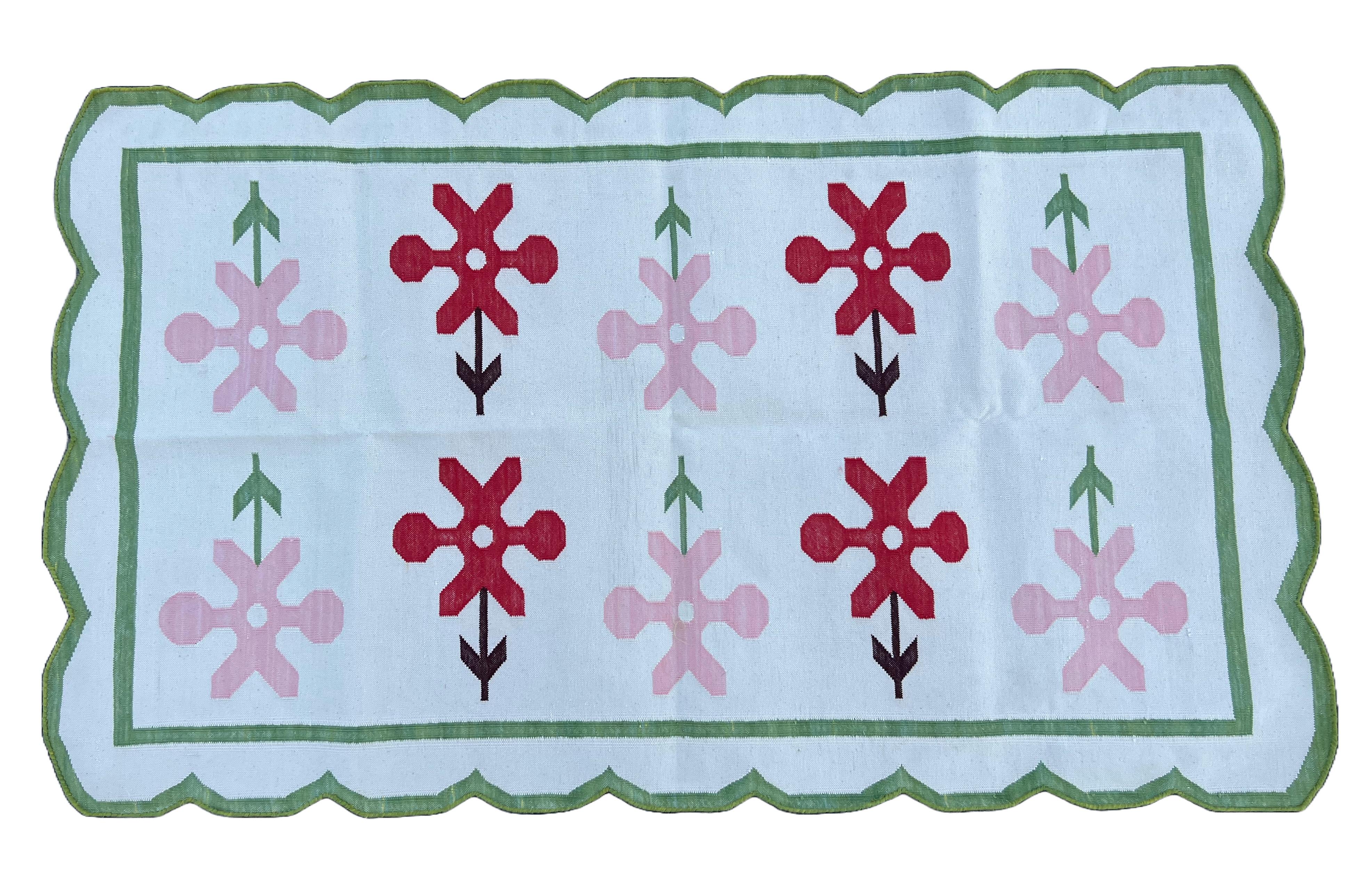 Tapis indien festonné Dhurrie en coton teint dans la masse crème, vert, rose et rouge - 90x150cm (3'x5') 

Ces dhurries spéciales à tissage plat sont tissées à la main avec du fil 100 % coton 15 plis. En raison des techniques de fabrication