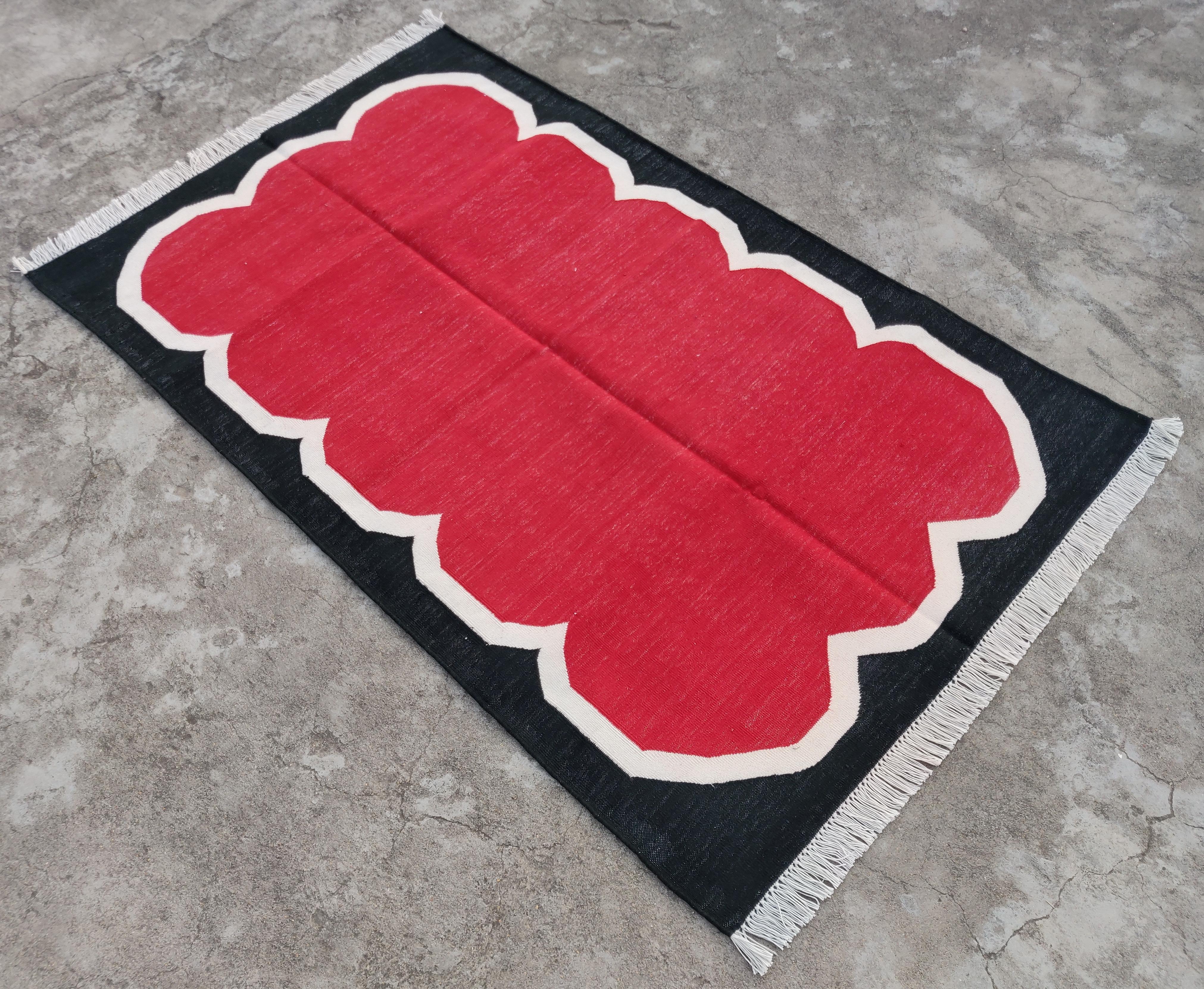 Tappeto Dhurrie indiano a righe smerlate in cotone tinto al vegetale rosso, crema e nero 3'x5' 
Queste speciali dhurry a trama piatta sono tessute a mano con un filo di cotone 100% a 15 strati. A causa delle speciali tecniche di produzione
