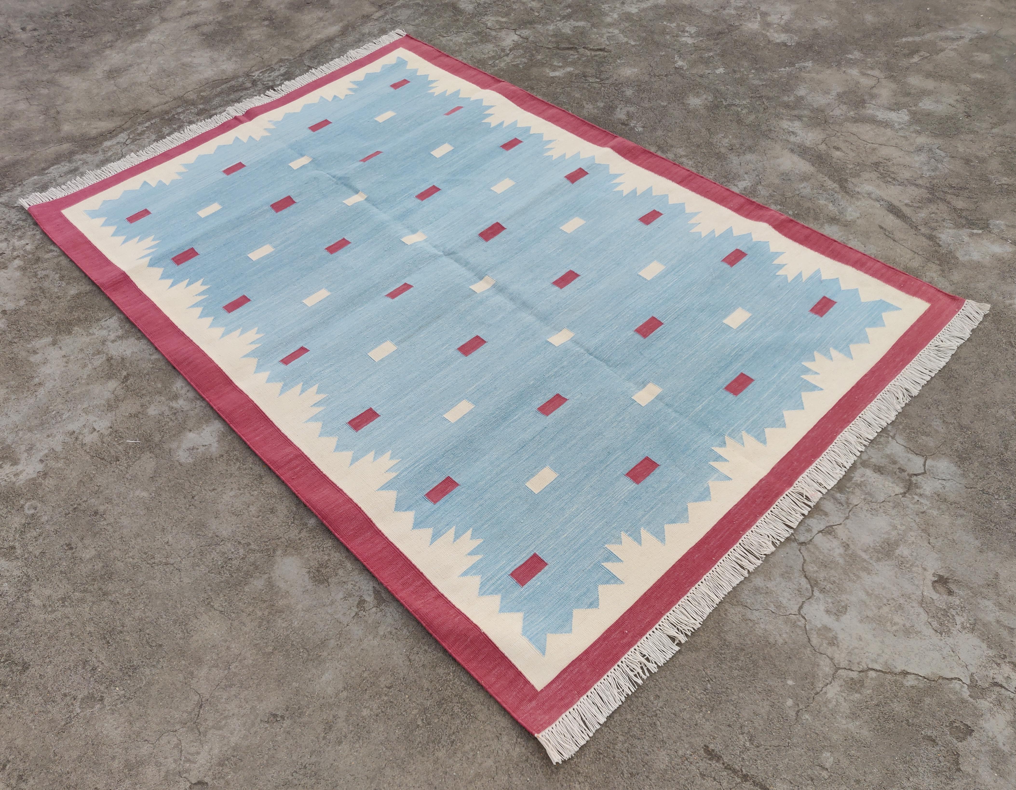 Tapis indien Dhurrie géométrique en coton teint dans la masse bleu ciel, crème et rose - 4 x 6 pieds 

Ces dhurries spéciales à tissage plat sont tissées à la main avec du fil 100 % coton 15 plis. En raison des techniques de fabrication spéciales