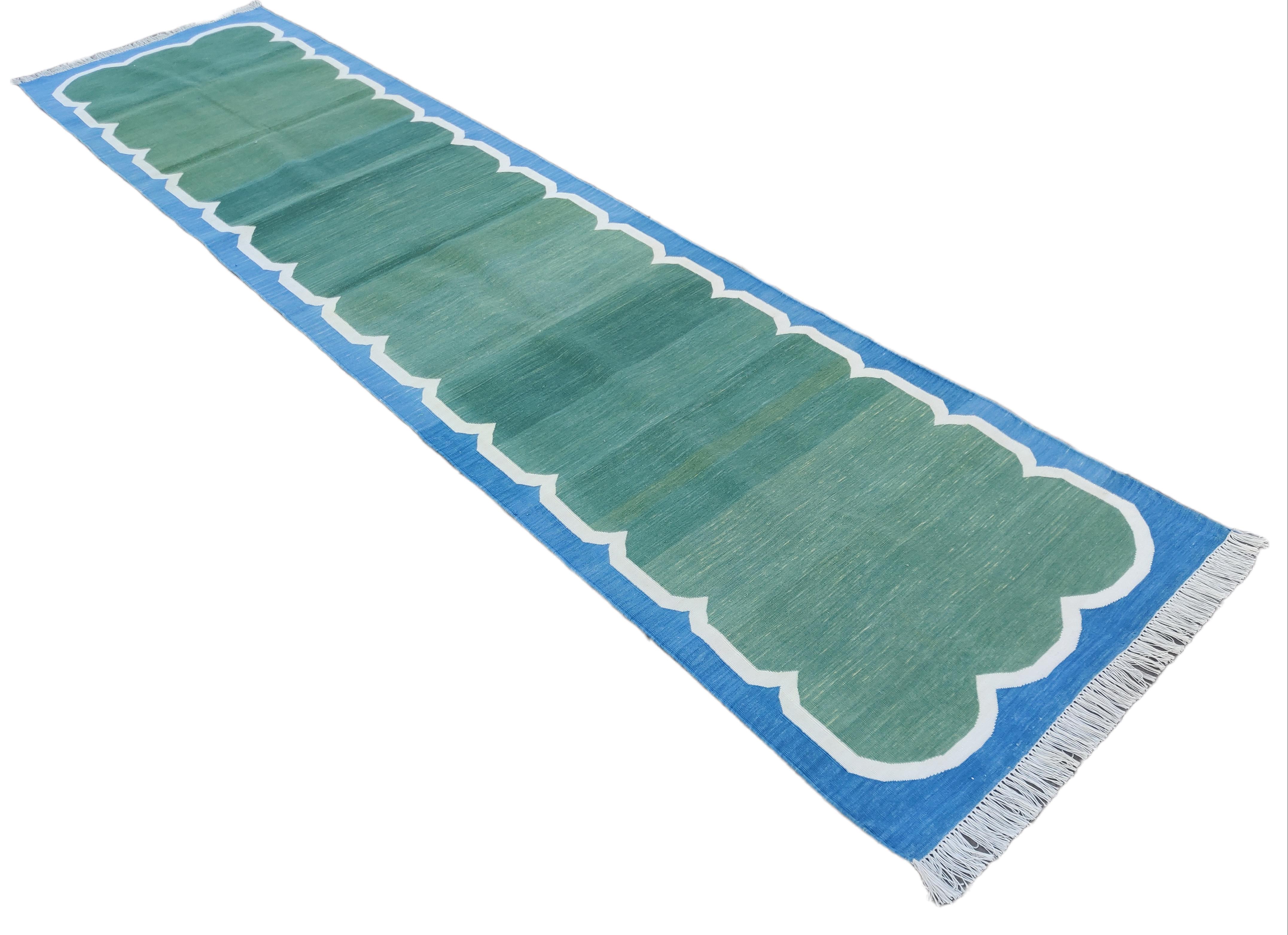 Tapis en coton teint dans la masse, vert forêt et bleu festonné Indian Dhurrie Runner-3'x12'.
Ces dhurries spéciales à tissage plat sont tissées à la main avec du fil 100 % coton 15 plis. En raison des techniques de fabrication spéciales utilisées