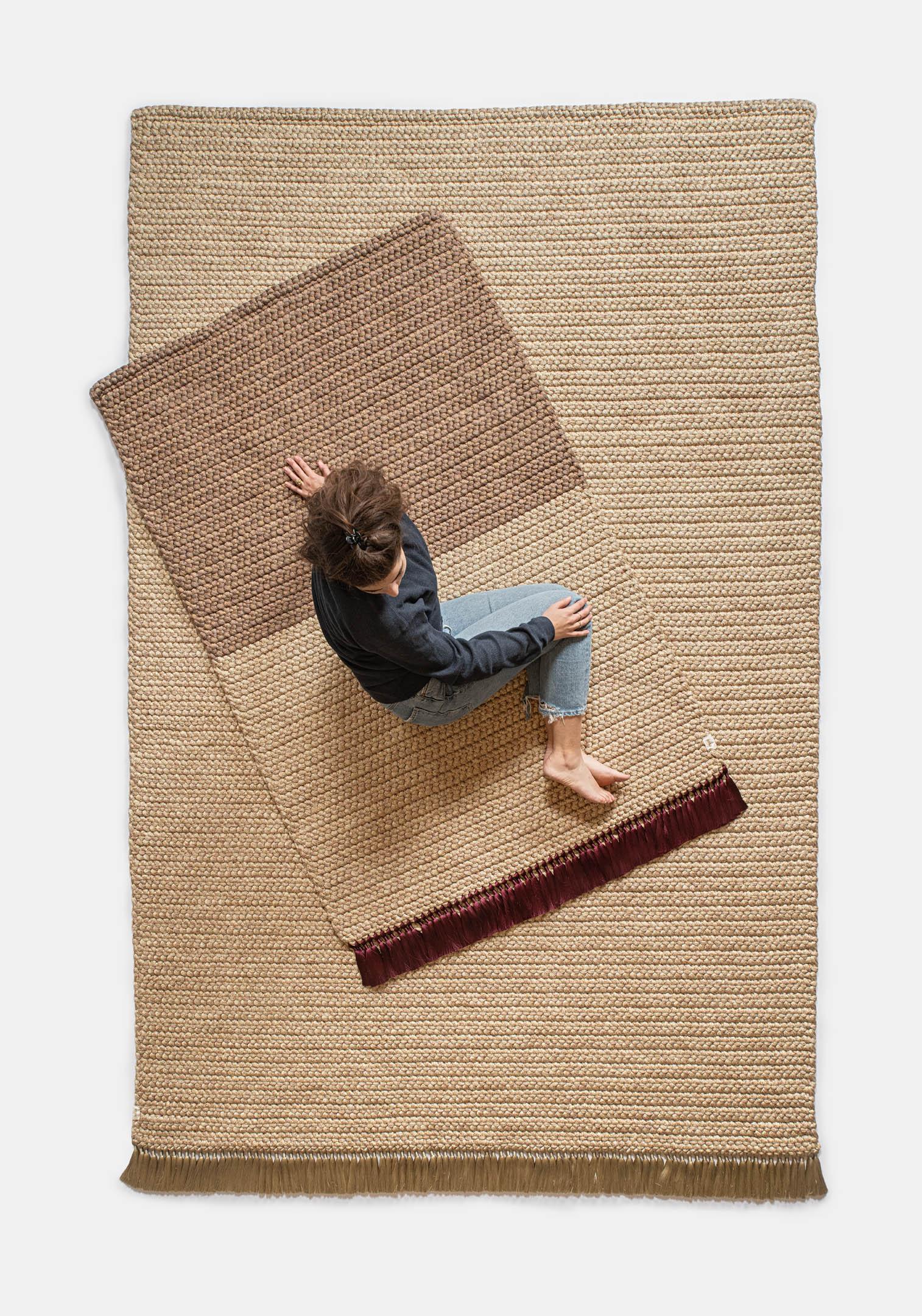 Zweifarbiger Teppich in Ingwer 
iota-Teppiche sind dick, weich, handgestrickt und luxuriös, dreimal dicker als ein Standardteppich. Die zweifarbigen, mittelgroßen Teppiche erzeugen einen subtilen Farbverlauf, der jeden Raum erhellt. Sie eignen sich