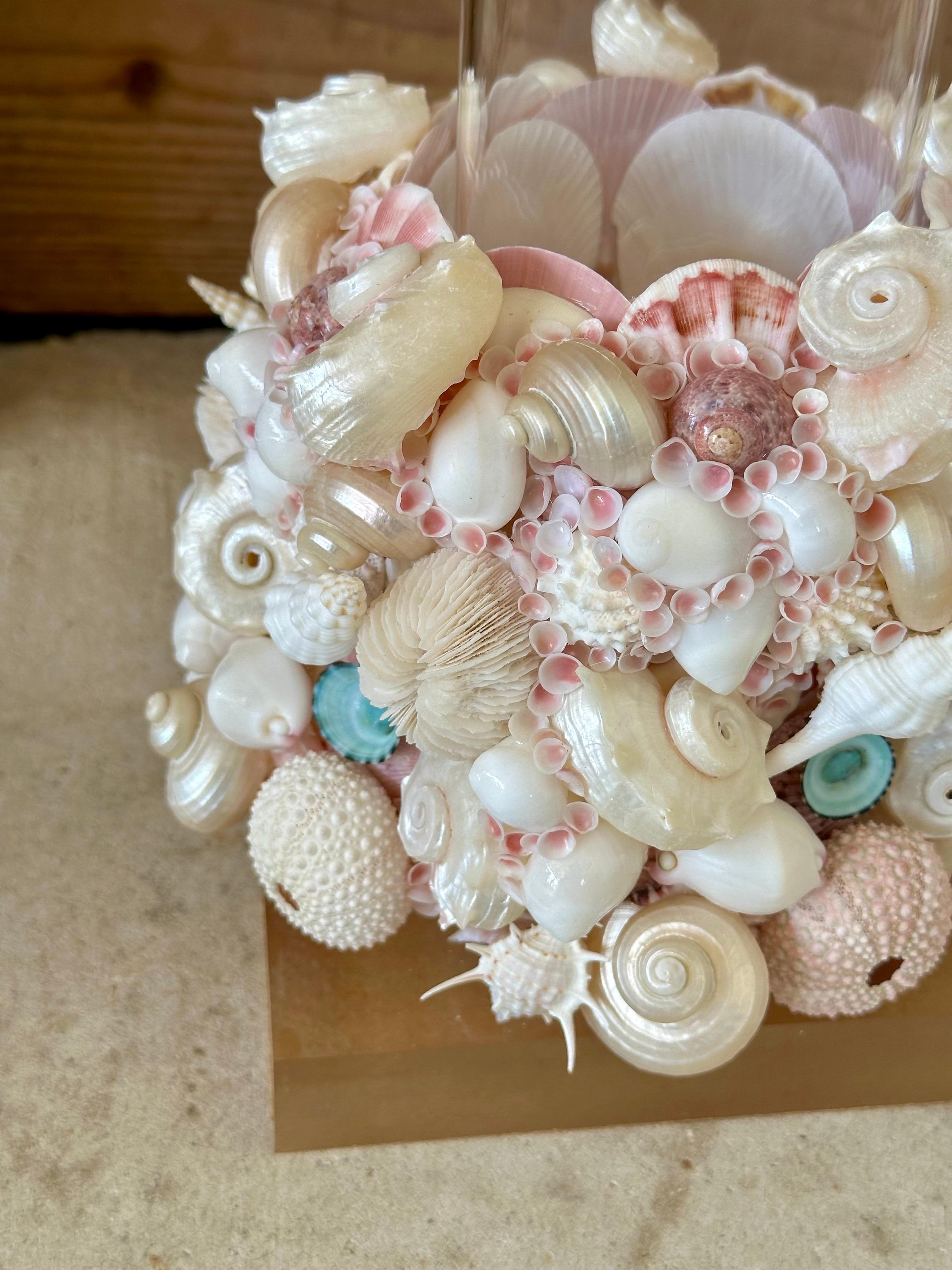 Handmade custom seashell hurricane candle holders, mounted on Lucite bases and new glass hurricane inserts.
Adorned with sea urchins, conchs and pink scallop shells they will look stunning on a table or mantle.

Please zoom in on all photos and