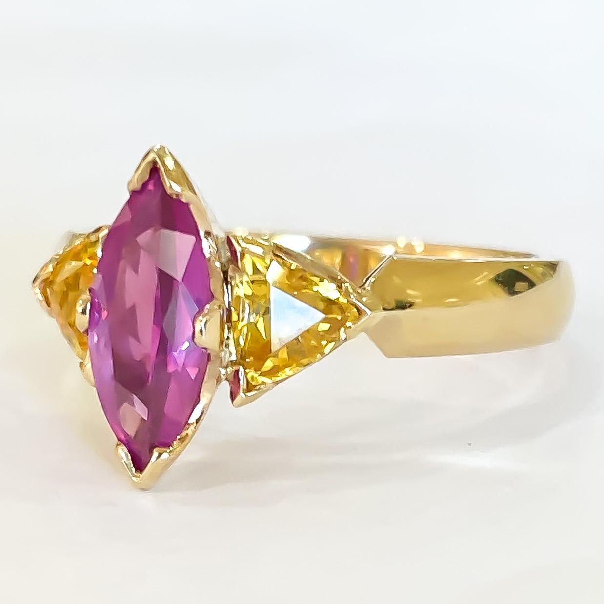 One of a kind custom handmade ring by Mark Areias Jewelers designed in 14 karat yellow gold. Set with one faceted marquise shape pink sapphire, flanked by two trillion golden sapphires. Handmade knife edge shank with chevron prongs. 

Center: