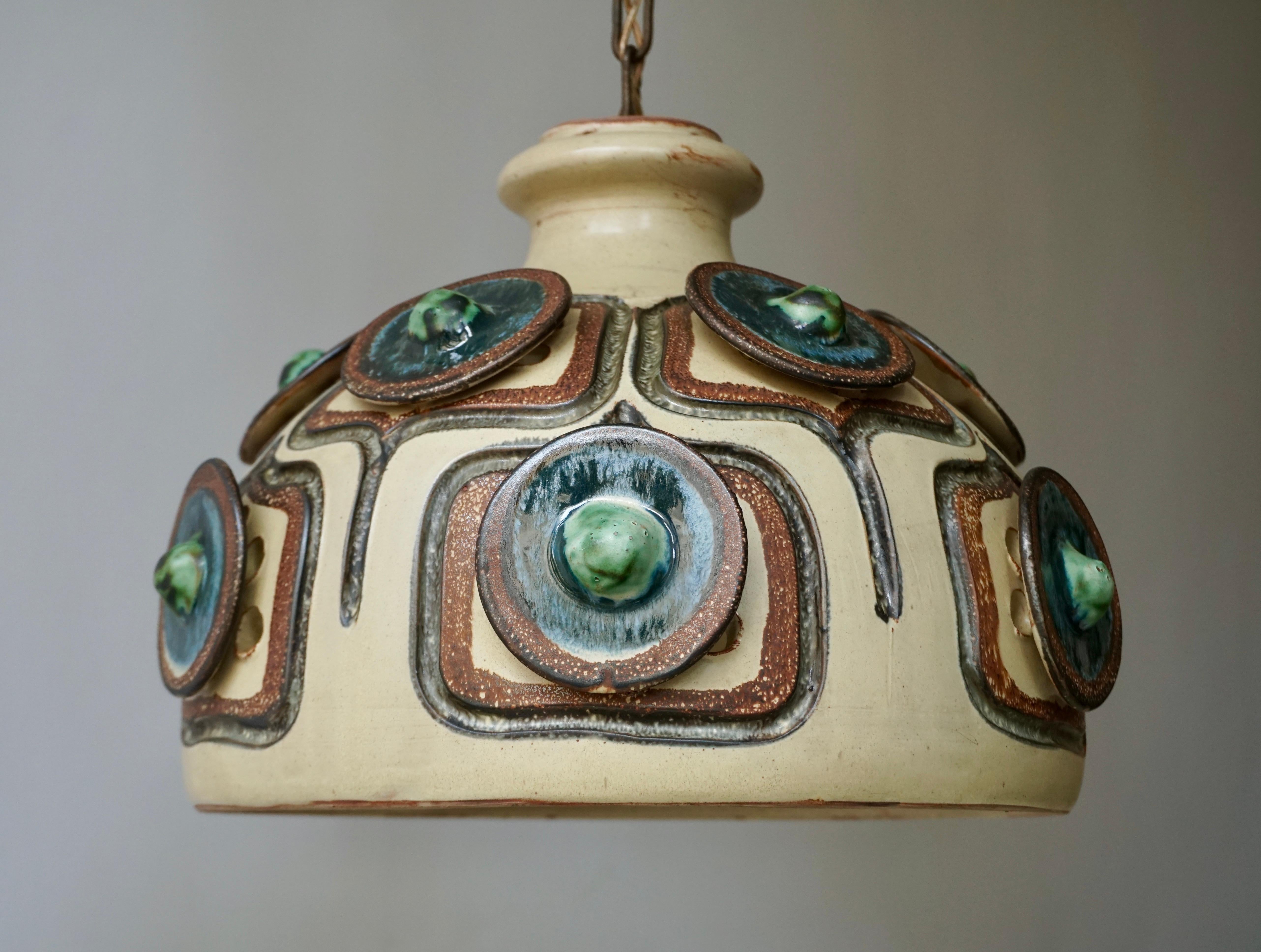Handmade Danish ceramic ceiling light made by Jette Hellerøe for Axella in the 1970s.
It´s glazed in a mix of beige, blue, brown and green colors.
The pendant takes one x E27 bulb max 60 watt.
Measures: Diameter 35 cm.
Height fixture 25 cm.
Total