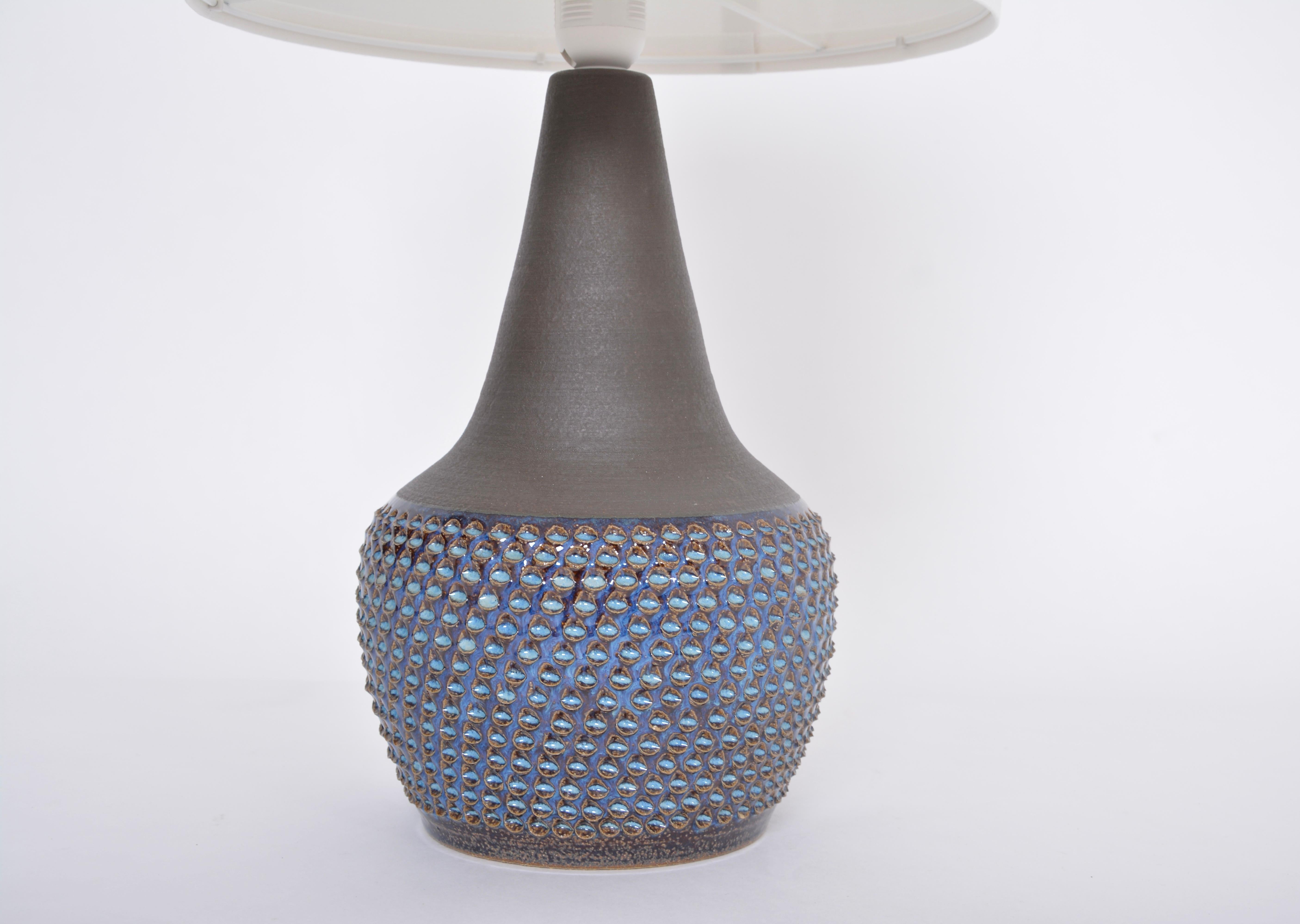Handmade Danish midcentury ceramic lamp Model 3048 by Einar Johansen for Soholm
Stunning table lamp handmade of stoneware with ceramic glazing in different tones of blue. Circular pattern to the base of the lamp. Produced by Danish company Soholm.