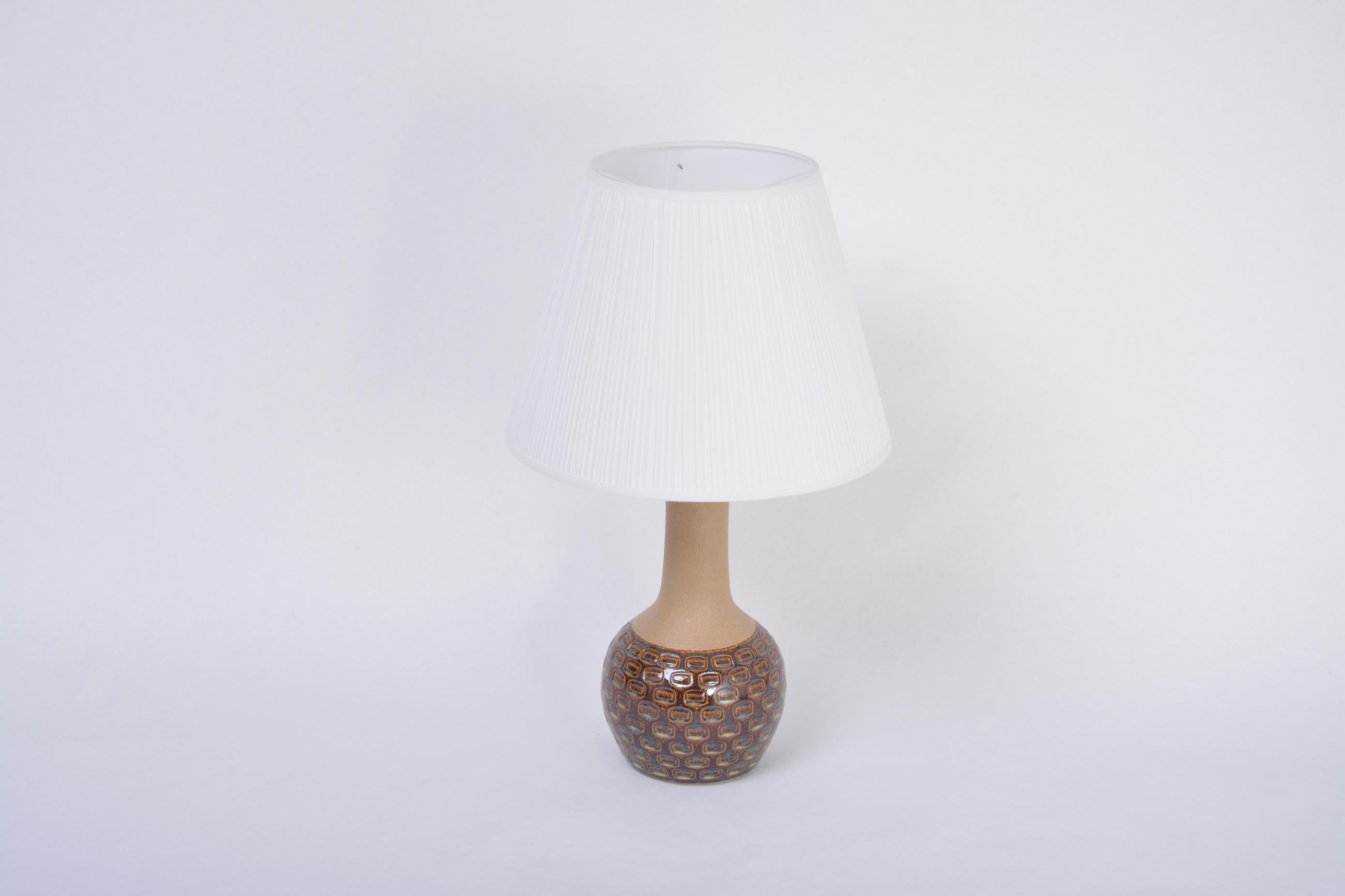 Handmade Danish Mid-Century Modern stoneware lamp with graphic pattern by Soholm
Table lamp handmade of stoneware with ceramic glazing in tones of brown and blue. Graphical pattern to the base of the lamp. Produced by Danish company Soholm. The