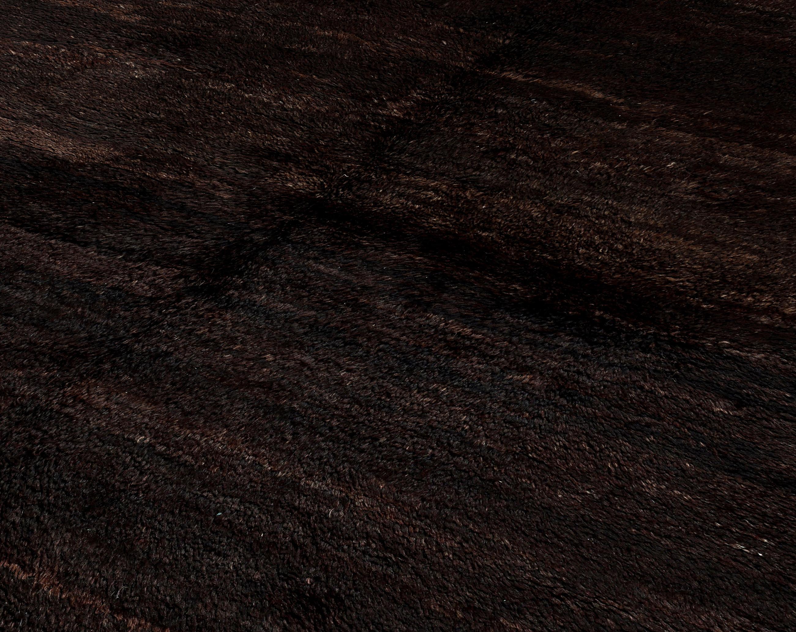 Dieser handgefertigte marokkanische Wollteppich in luxuriösem Dunkelbraun und authentischer, vom Berber inspirierter Schlichtheit wertet Ihren Raum auf. Dieser Teppich, der von erfahrenen Handwerkern sorgfältig gewebt wurde, zeigt das reiche Erbe