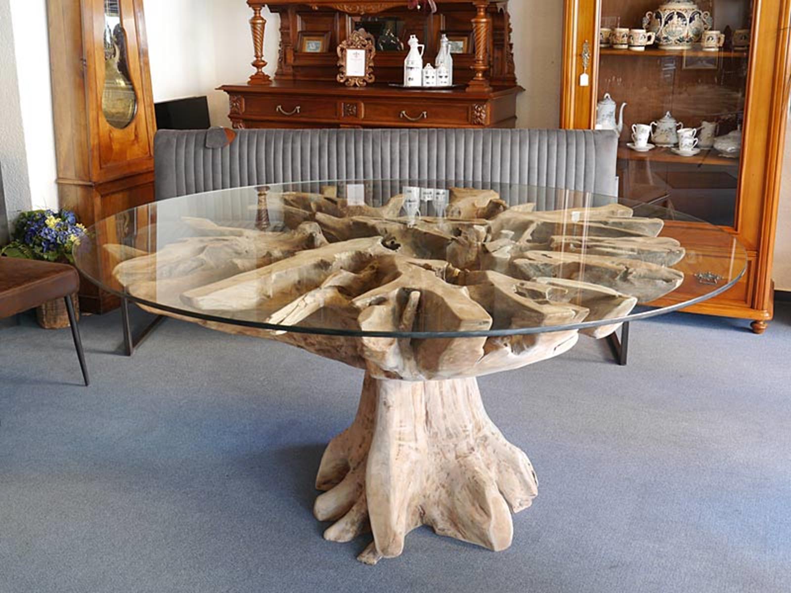 Exceptional dining table consisting of two giant teak tree roots combined with a 170 cm round glass top.
Due to the transparency of the glass, the structuring and shape of the root branches are very visible.
In particular, the wild, torn and