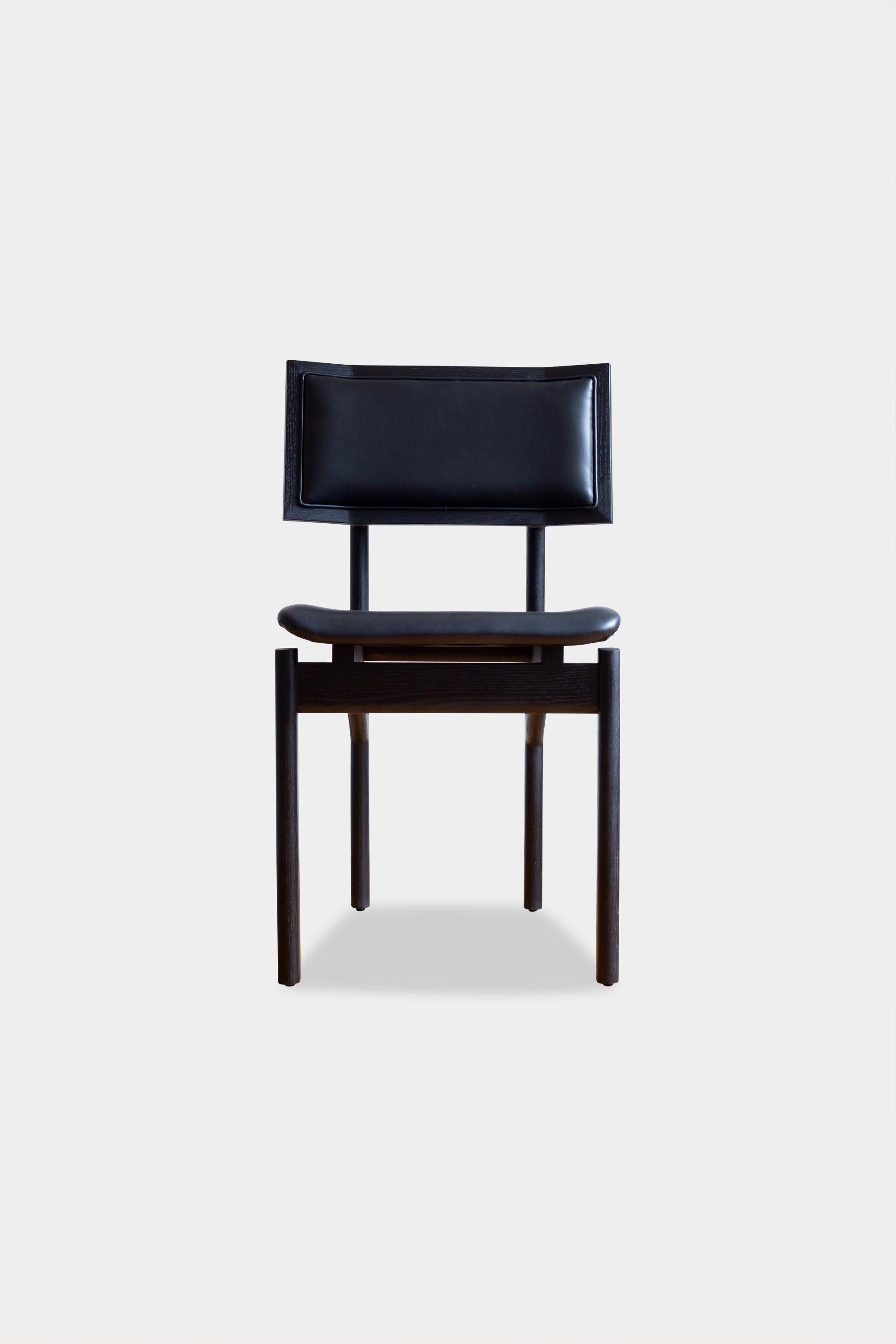 Solid wood constructed dining chair available in any American domestic hardwoods; specifically walnut, oak, ebonized oak, or ash. Featuring hand-shaped legs, a custom upholstered seat available in camel leather, olive leather, black leather, vegtan