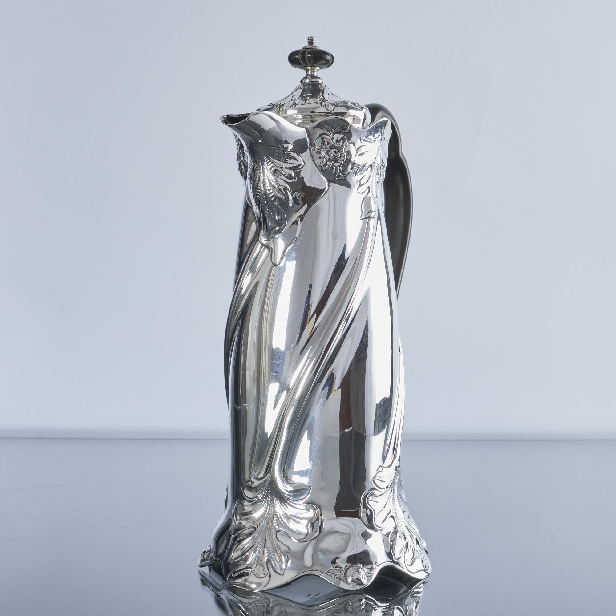 Une cafetière ancienne en argent très stylisée dans le style Arte Antiques. Réalisée au début du XXe siècle, cette jolie cafetière en argent ciselé à la main, avec sa forme naturelle et tourbillonnante, personnifie le style et l'époque de l'Art