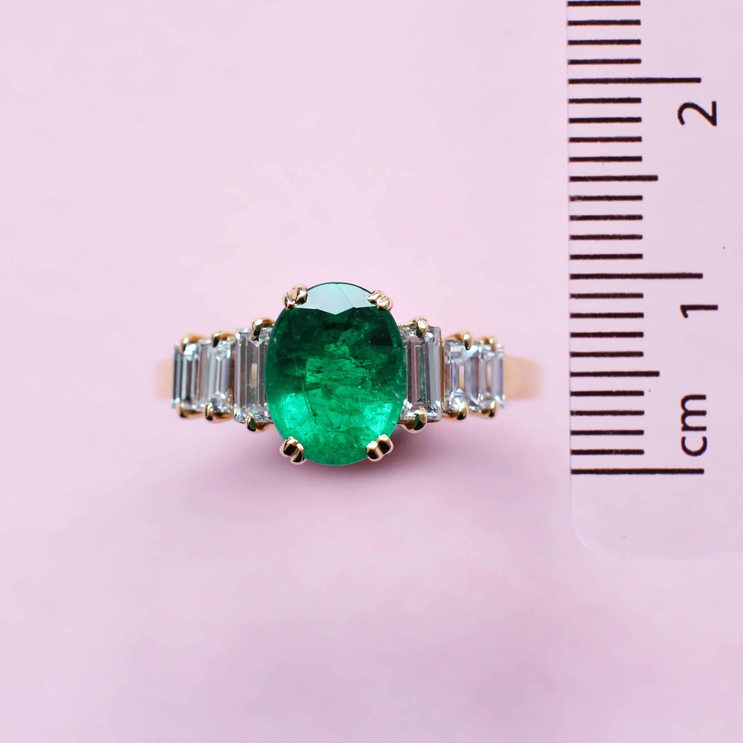 Feel extraordinary in this timeless emerald ring, which was handmade in the Haruni atelier. The main stone is cut in a classic oval shape and is a vivid green colour, accentuated by the glittering white of the baguette diamonds that shoulder it.
