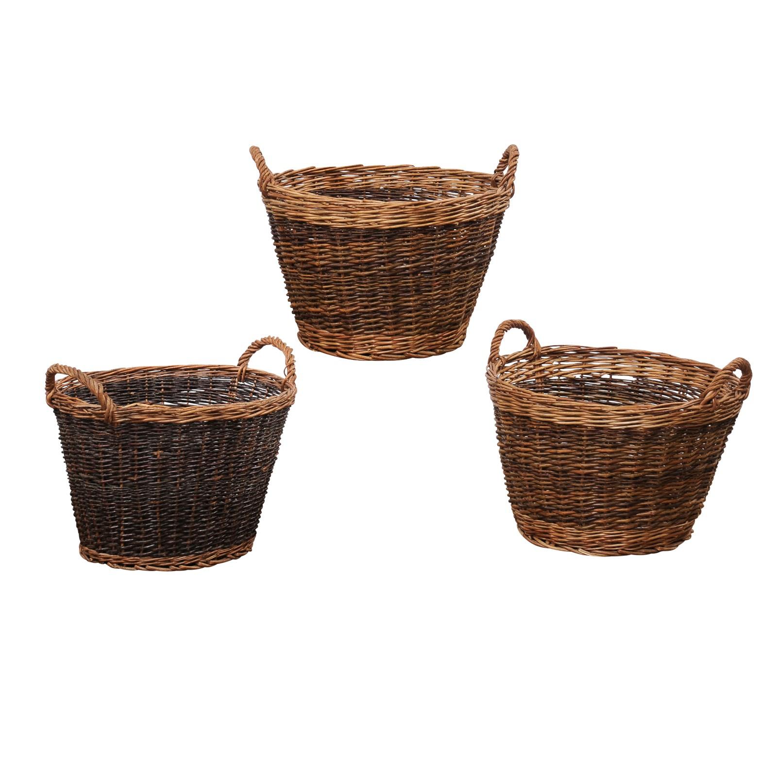 Three English wicker baskets with double handles, priced and sold each. Step into the world of English craftsmanship with these exquisite 20th Century wicker baskets, sourced from a private estate in Devon. These baskets, known for their robust