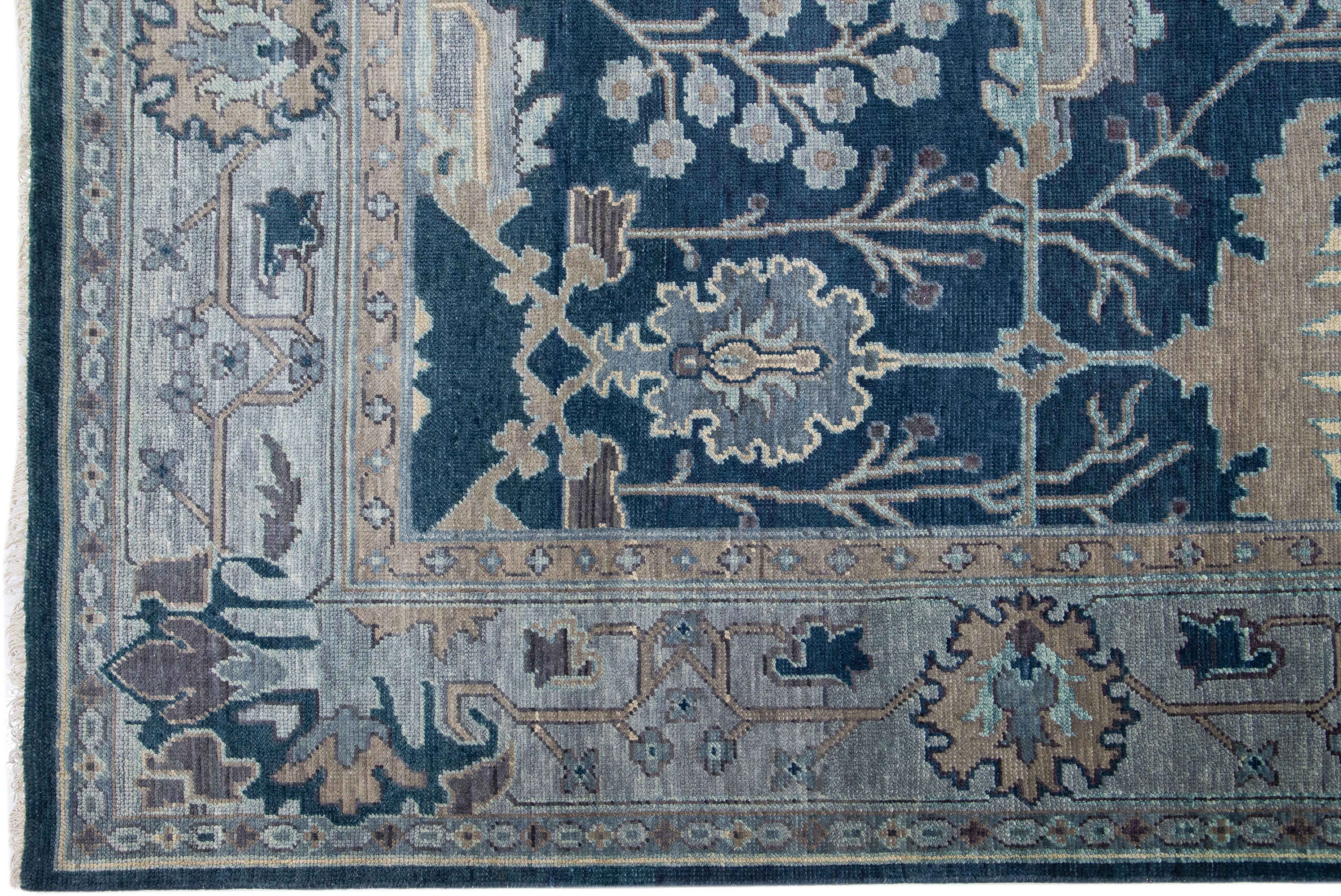 Beautiful modern Oushak hand-knotted wool rug with a blue field. This Turkish rug has a gray-designed frame with brown and beige accents in a gorgeous all-over floral pattern design.

This rug measures: 10' x 13'11