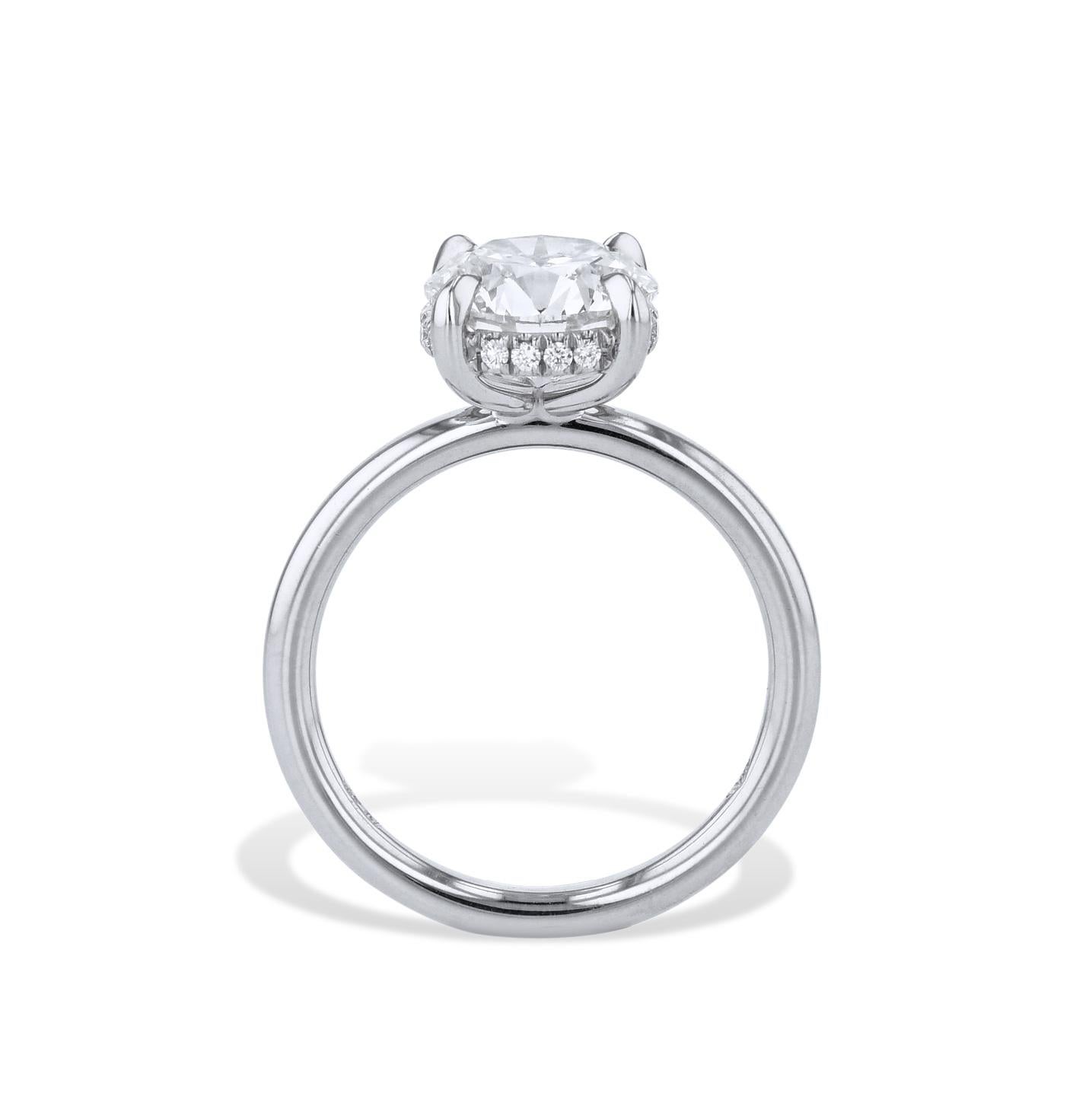 This Round Diamond Platinum Engagement Ring is a masterpiece of craftsmanship, featuring an exquisite Round Brilliant Cut diamond set in the center. 16 glittering diamonds are pave-set under the basket, forming an eye-catching halo. Handmade by the