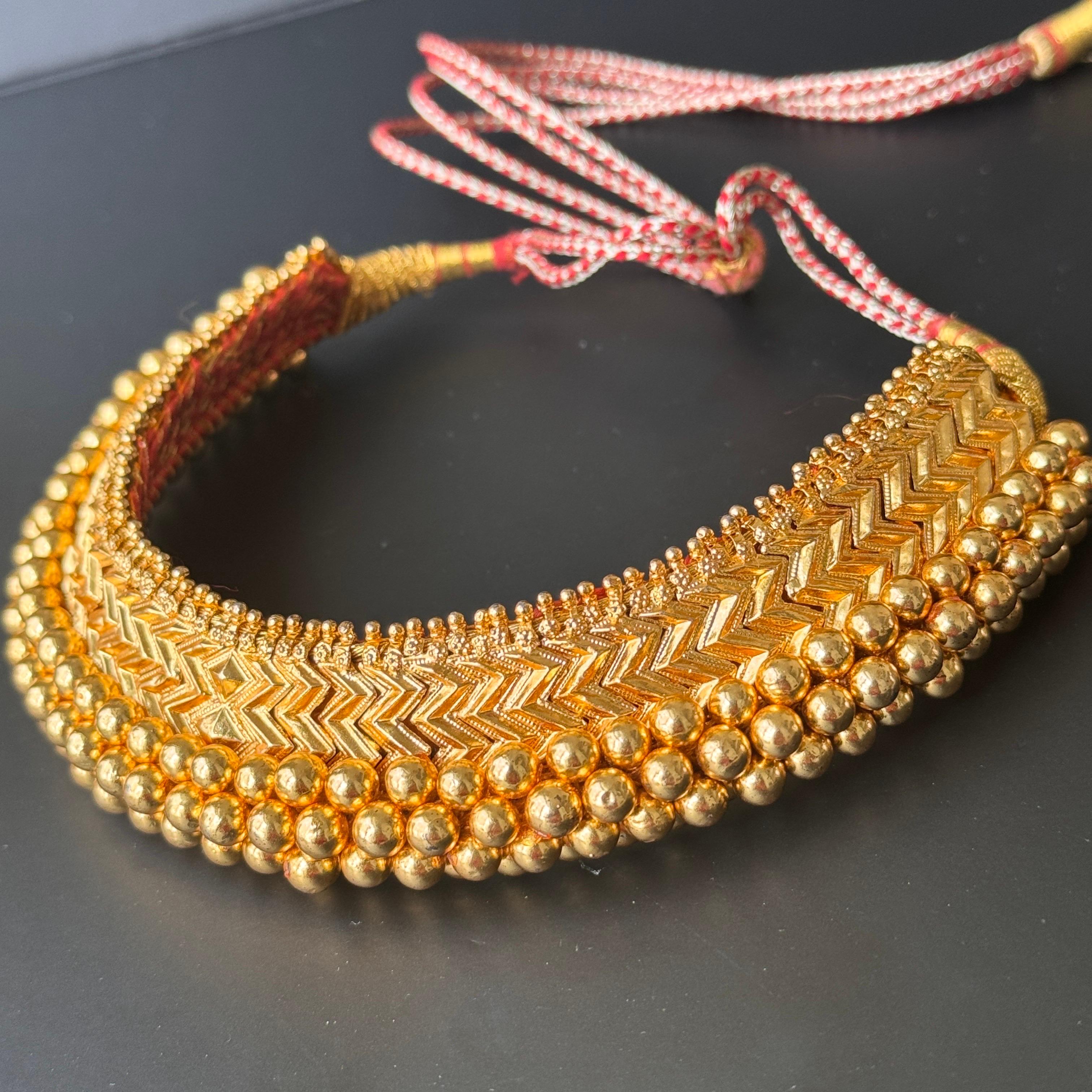 Questa splendida collana girocollo fatta a mano presenta pannelli in argento dorato meticolosamente lavorati, ognuno dei quali è decorato con motivi intricati. I pannelli sono sapientemente tessuti su un ampio filo di seta con un bordo di perline,