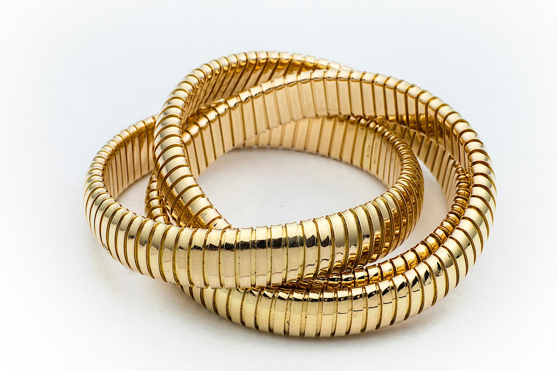 With a timeless but modern style, this chic intertwined three strand 12mm tubogas rolling bangle bracelet was originally inspired by the flexible automotive gas tubing of the 1920’s. Translated into luxurious 18 karat yellow gold and easily stacked