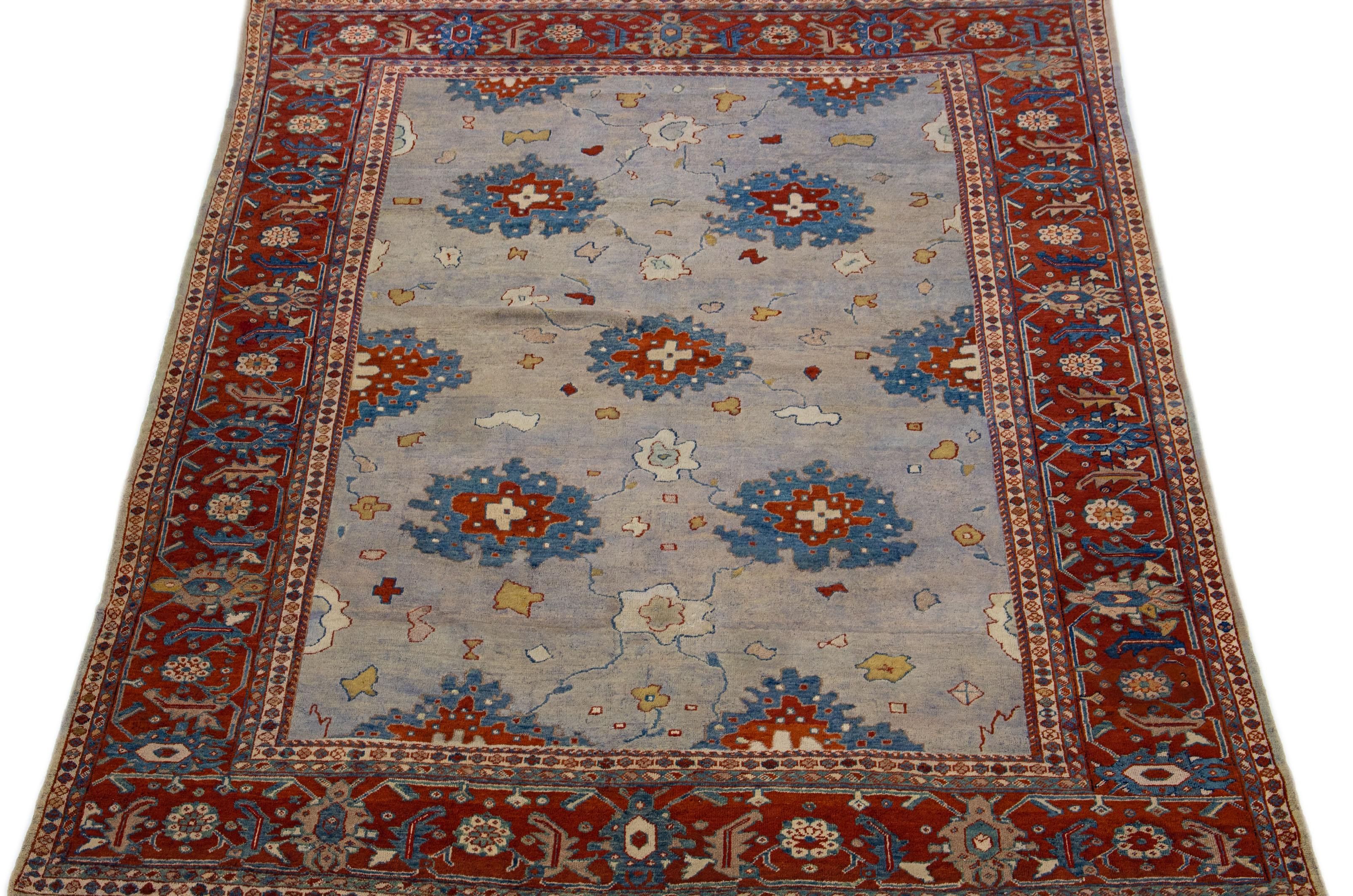 This antique Persian wool rug has exquisite craftsmanship and intricate hand-knotted mahal design. The gray color field complements the rusted frame, adorned with delicate blue and beige accents in an elegant all-over floral pattern.

This rug