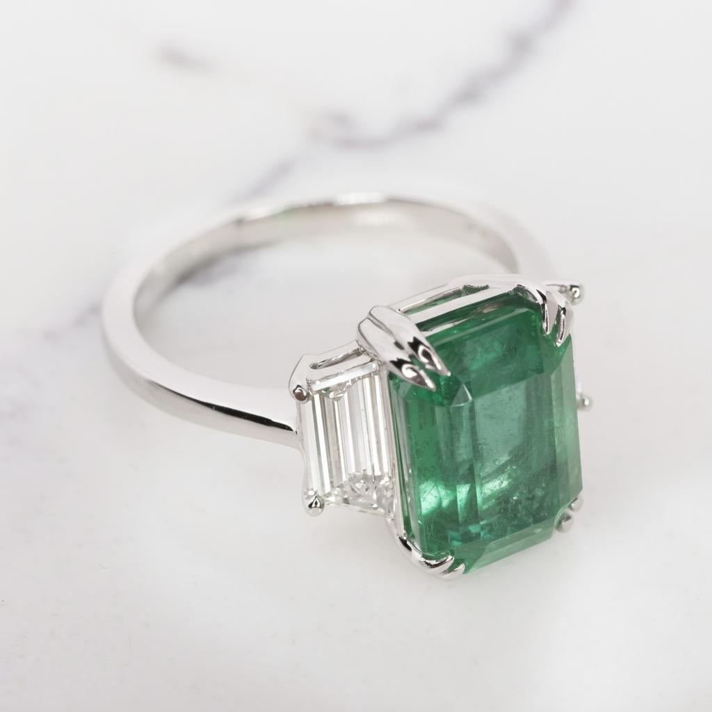 Une exquise émeraude verte de 4 carats, pratiquement sans inclusions et d'une couleur verte éclatante !
Le côté 

EXQUISITE EMERALD AND DIAMOND RING Cette merveilleuse bague à 3 pierres est ornée d'un Rare...  Émeraude pesant 4 cts. Le véritable