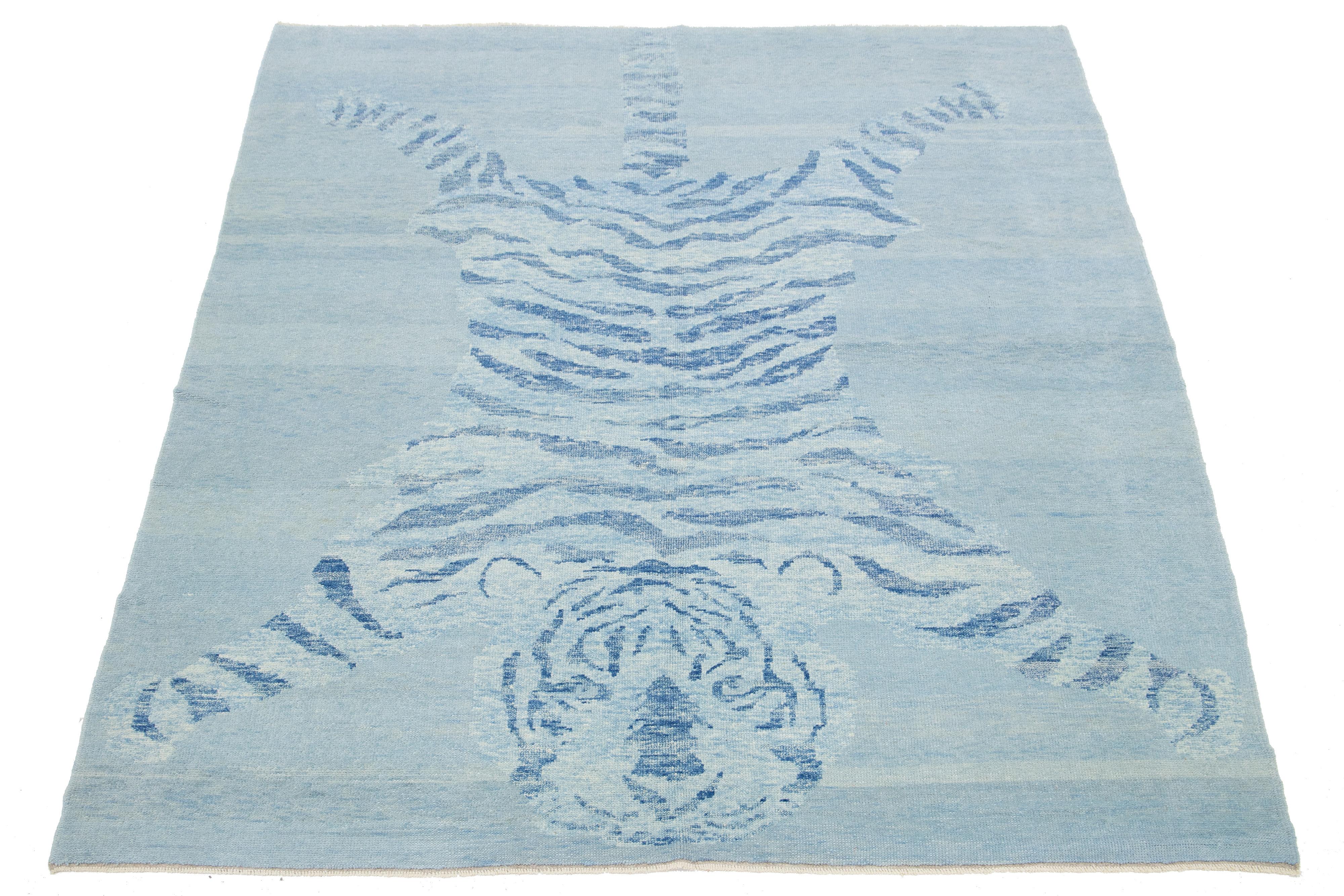 This beautiful Turkish Art Deco wool rug features a blue field with beige accents and a stunning pictorial design of a tiger.

This rug measures 6'3