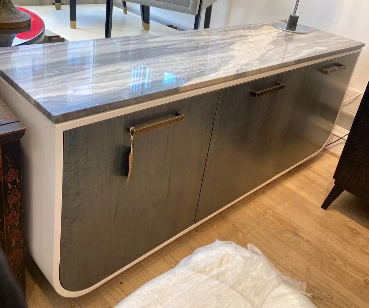 A high quality bespoke handmade in the UK sideboard featuring a statement marble top with white and grey detailing, the doors are a smooth texture in a complementary sage green colour with a subtle design. 

The sideboard has a white frame and solid