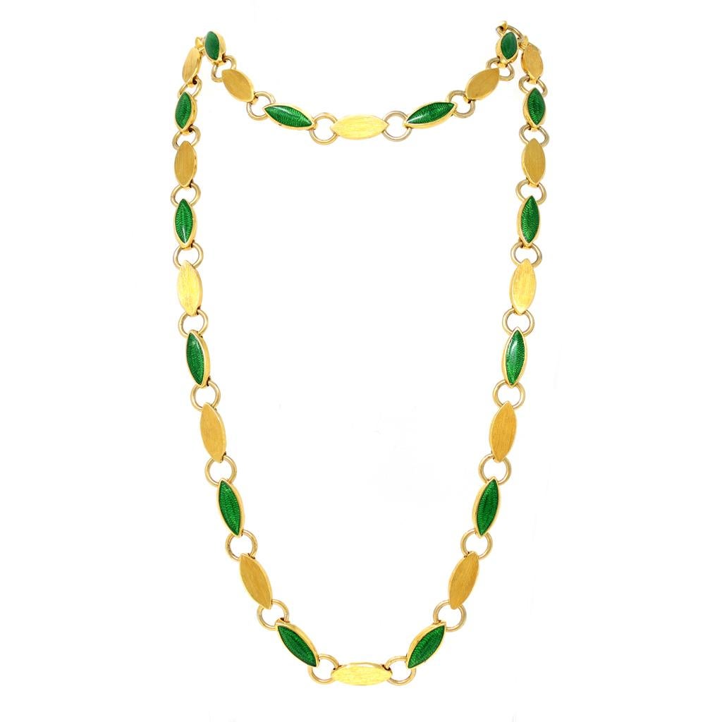 An Italian eternity guilloche green enamel link long necklace from the 1970s, in 18K yellow gold. Hand-made in Italy, this long link necklace features a delicate rhythm of green enameled guilloche navette motifs, alternating with 18K gold ones. The