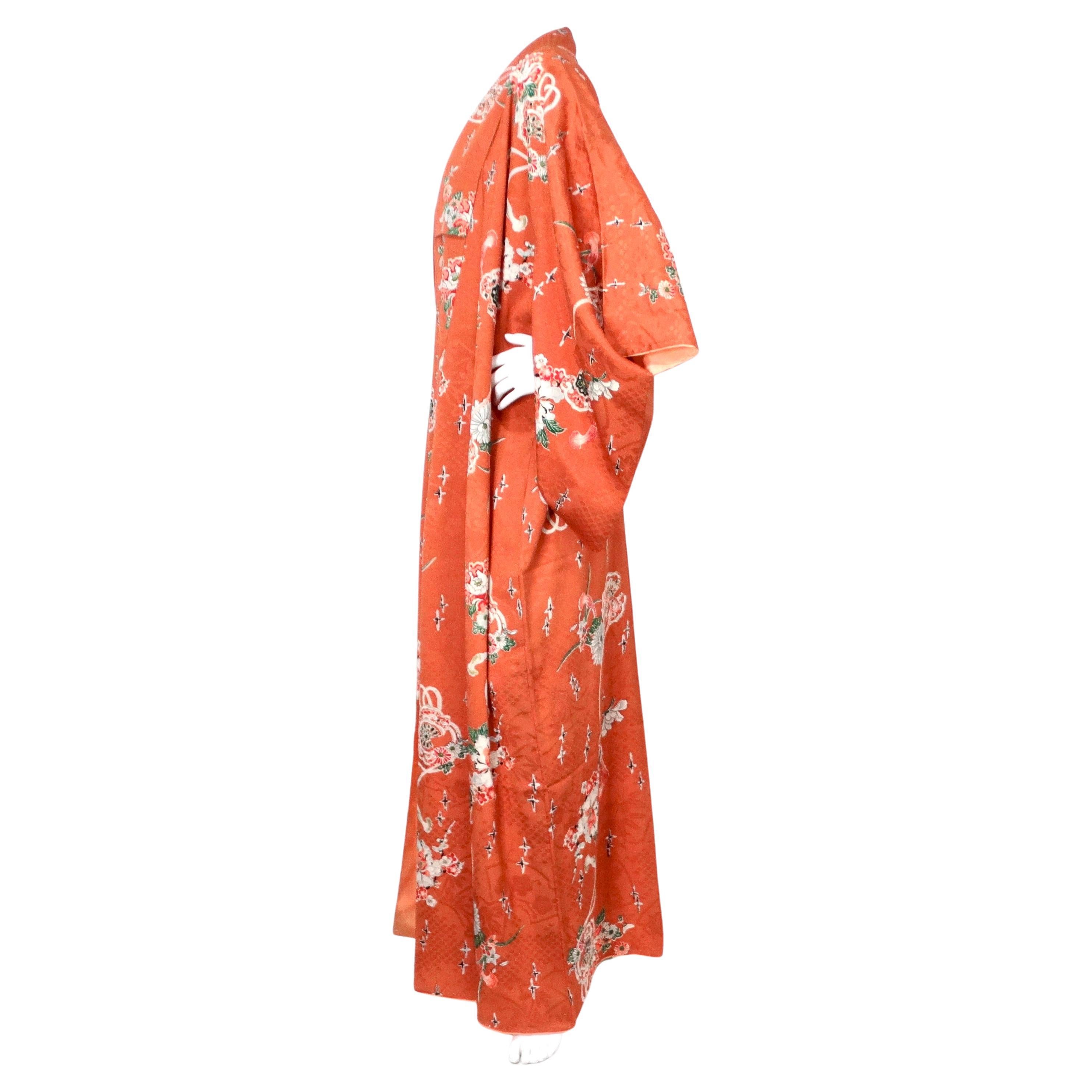 Il kimono giapponese fatto a mano con stampa floreale arancione bruciato, risalente agli anni '50 circa, è uno splendido esempio di artigianato tradizionale che si fonde con un'eleganza senza tempo. Realizzato in lussuosa seta, questo kimono