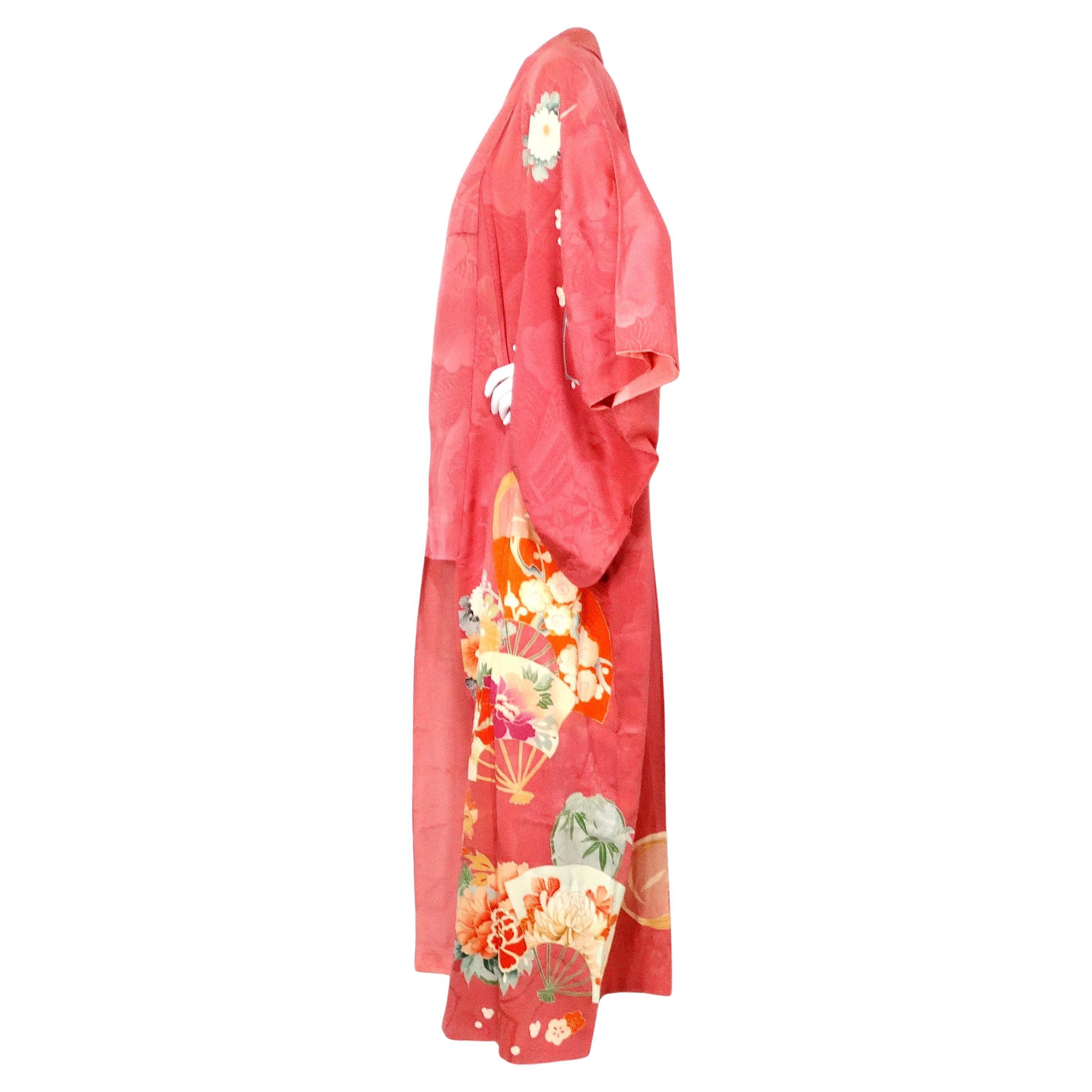 This exquisite Handmade Japanese Coral Floral Print Silk Kimono from the circa 1950s is a stunning example of traditional craftsmanship and timeless elegance. Crafted from luxurious silk, the kimono features a vibrant coral floral pattern that