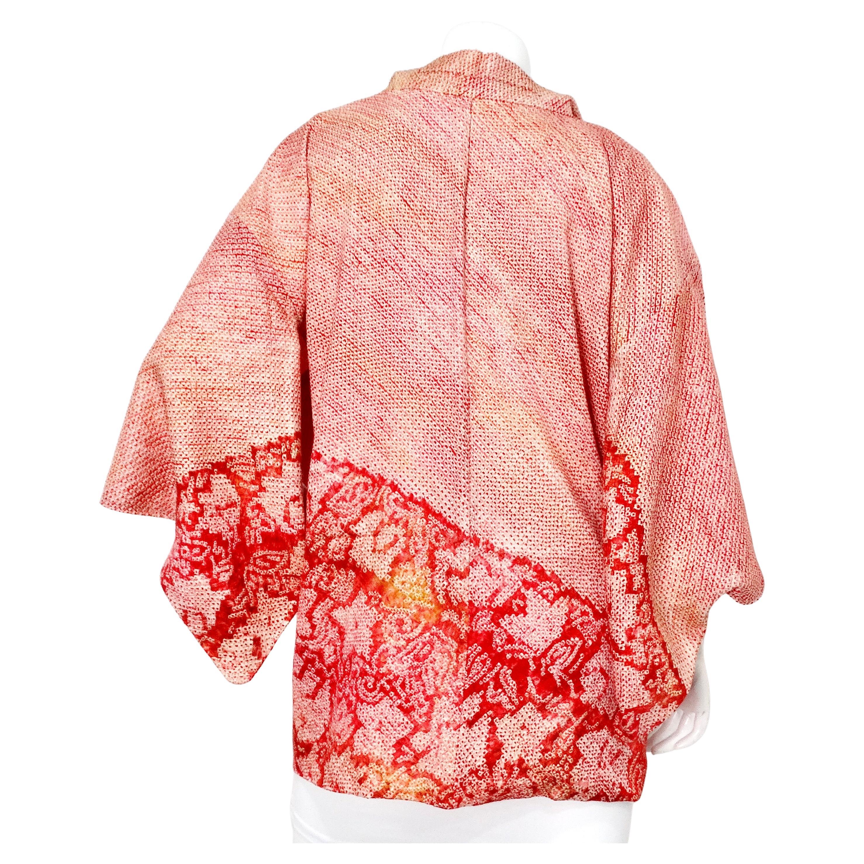 La giacca Haori Kimono giapponese rosa Shibori stampata a mano è un pezzo straordinario che incarna l'artigianato tradizionale fuso con l'eleganza moderna. Realizzato in lussuosa seta, questo kimono è caratterizzato da un'intricata tecnica di