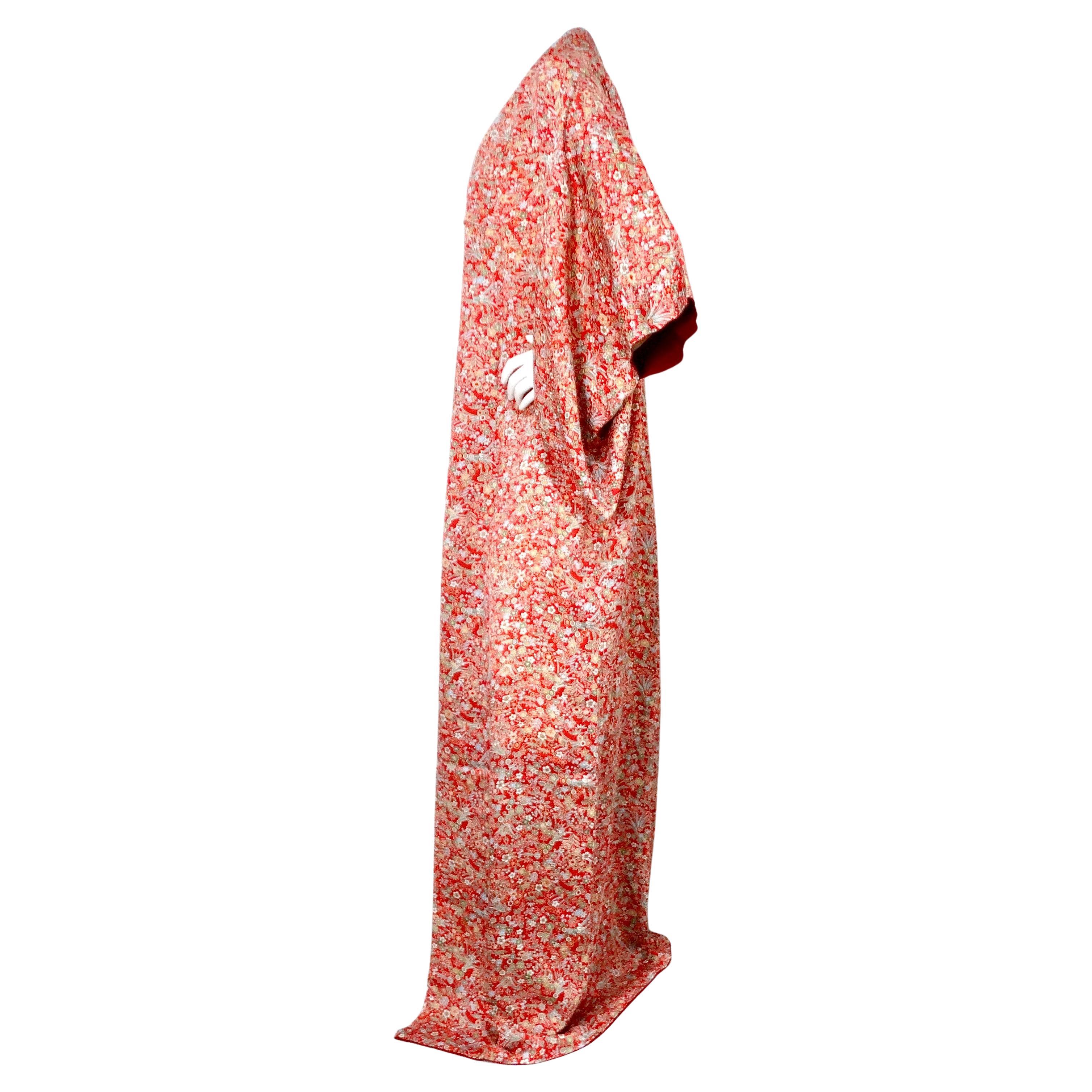 Dieser exquisite handgefertigte japanische Seidenkimono mit rotem Blumendruck aus den 1950er Jahren ist ein Beispiel für zeitlose Eleganz und exquisite Handwerkskunst. Der aus luxuriöser Seide gefertigte Kimono ist mit einem leuchtend roten