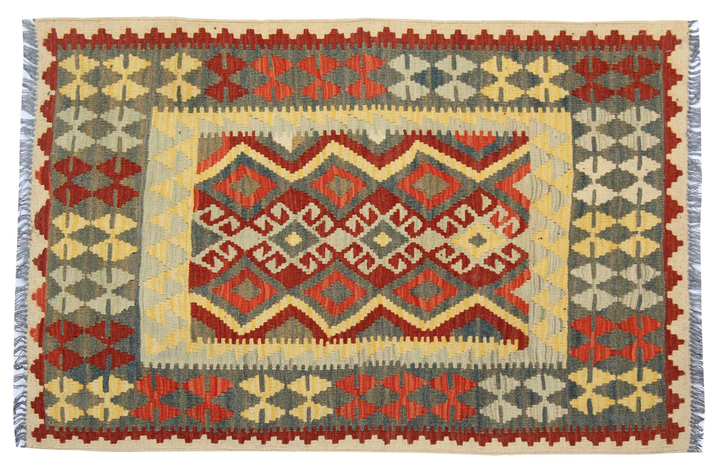 This elegant wool rug was woven by hand in the early 2000s in Afghanistan. The central design has been woven with a geometric, symmetrical pattern woven in accents of beige, red and green. Featuring tribal motifs throughout both the centre and