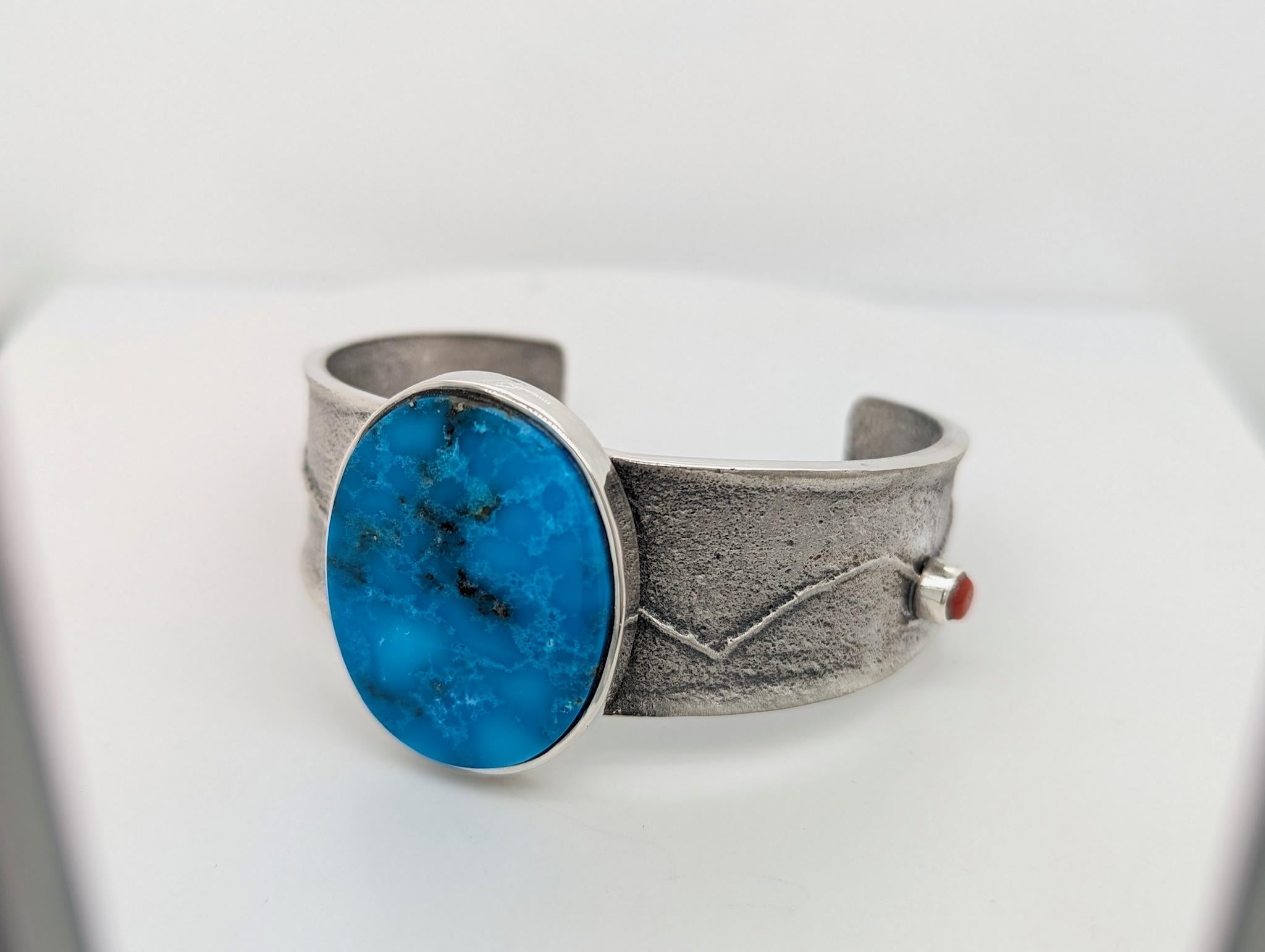 Embrace the beauty of nature's textures with this captivating Medium Handmade Bracelet. This unique piece features genuine Kingmalaquoise gemstones, meticulously set in a tufa cast base for an organic and earthy look. Accents of vibrant coral add a