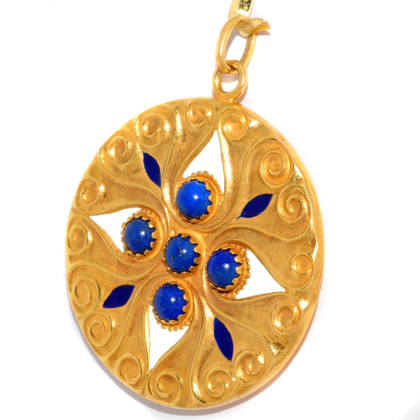 This round filigree pendant was made in 1960s and features 4 natural lapis lazuli stones and enamel accents set in 18k yellow gold. Measurements: 1.61