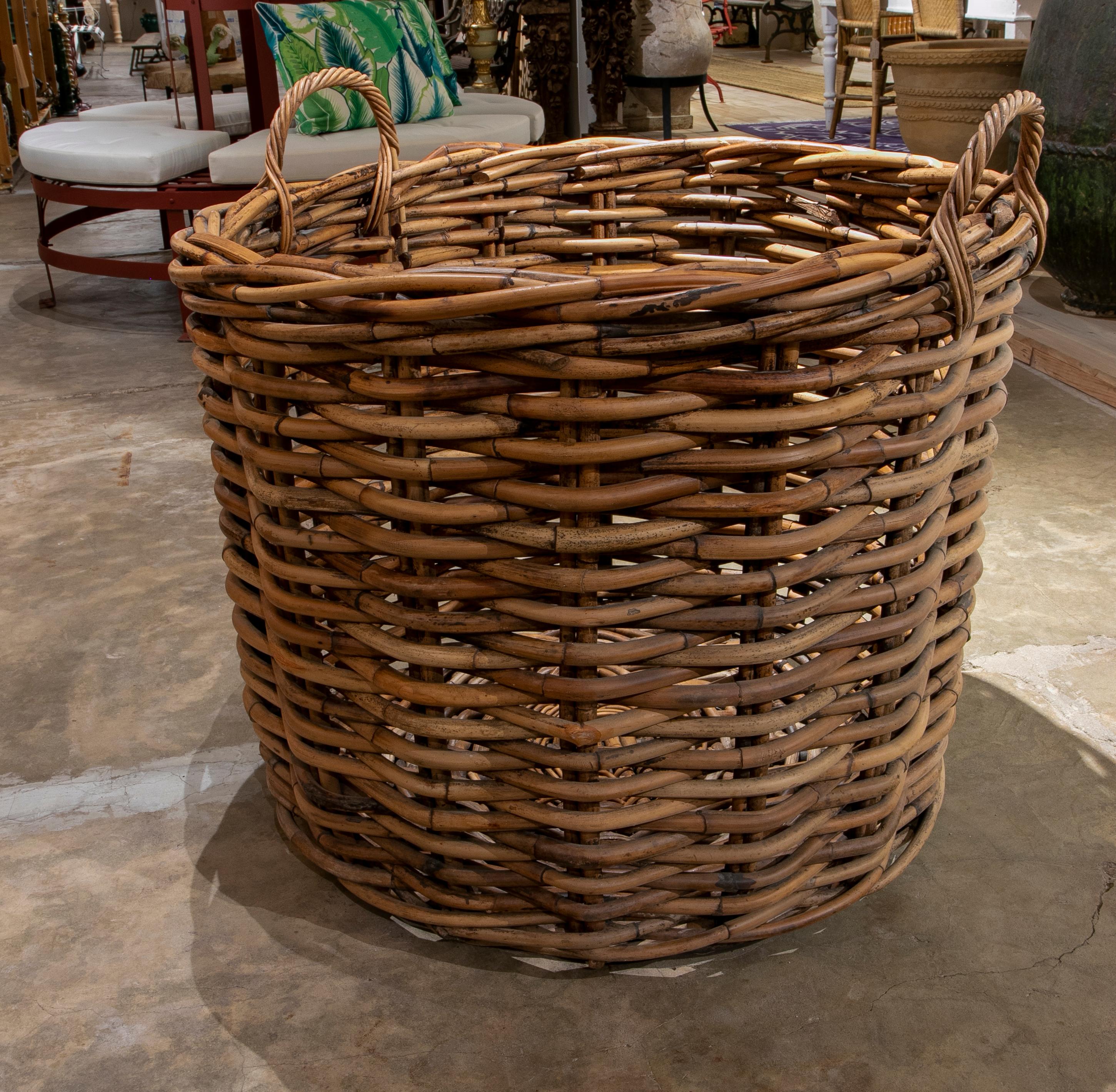Handmade large bamboo basket with handles for plants or storage.