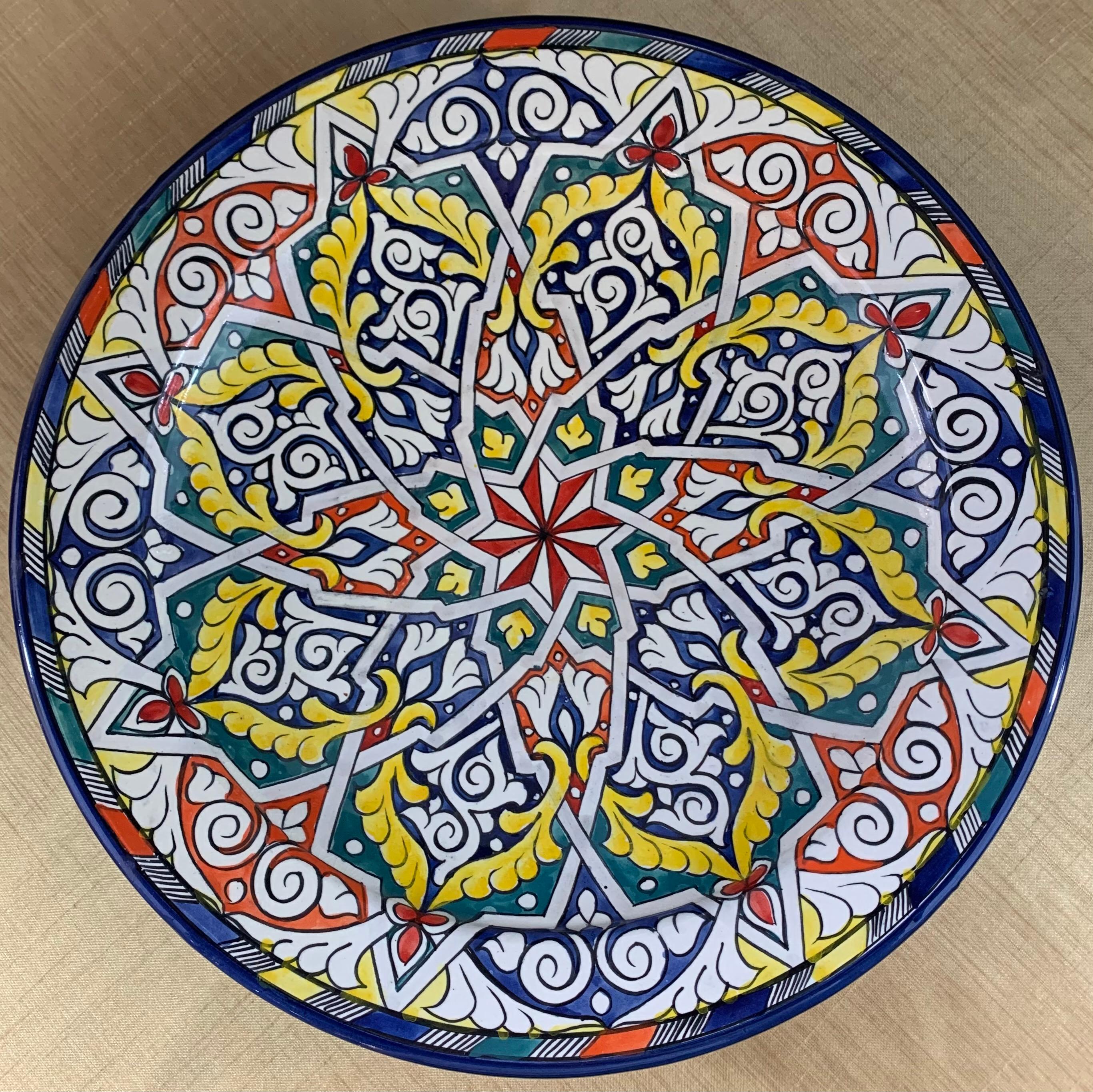 Intricate and ornate arabesque motifs in mesmerizing colors define these large, gorgeous ceramic dinner plates. Handcrafted in the bustling workshops of master artisans in the coastal city of Safi, this lovely plate can be wall-mounted as decorative