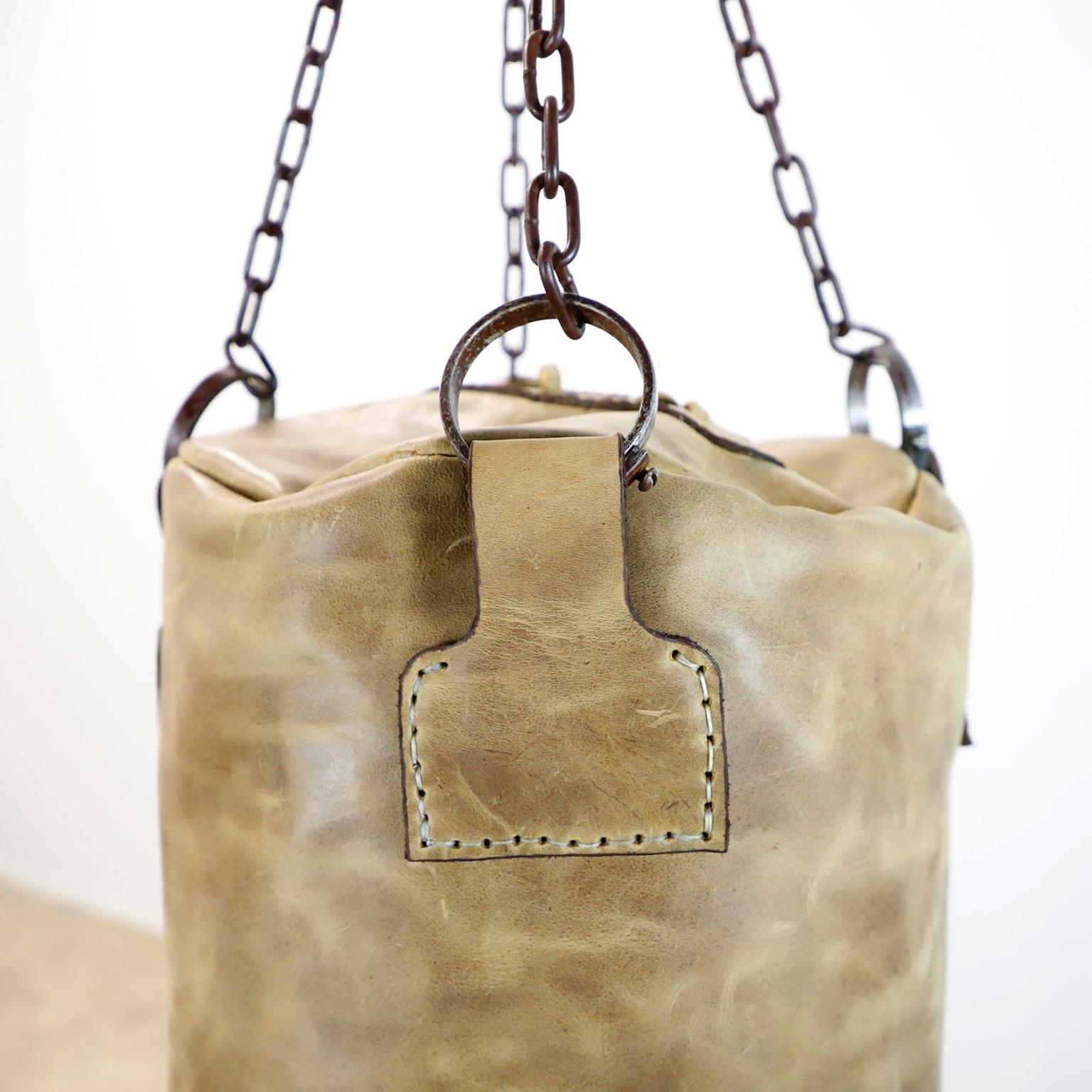 Ti offriamo questo sacco in pelle da palestra per boxe e pugilato. Questo pezzo è realizzato in pelle e catene vintage seguendo il design degli antichi sacchi da boxe, totalmente fatti a mano. Include le catene ma non il materiale all'interno della
