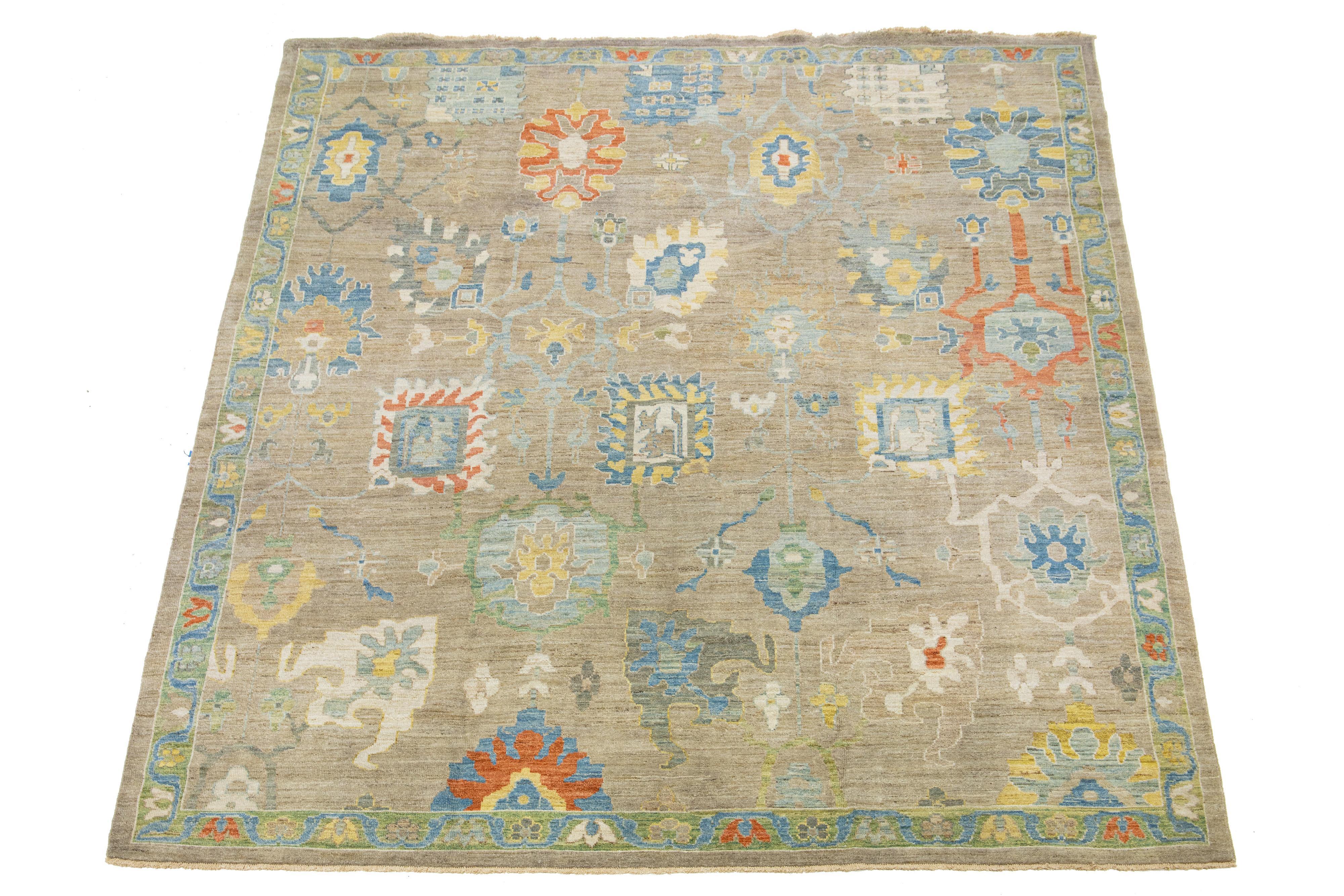 Beautiful modern Sultanabad hand-knotted wool rug with a light brown field. This Sultanabad rug has beige, Orange, Yellow, and blue accents in a gorgeous classic floral pattern.

This rug measures 10'2