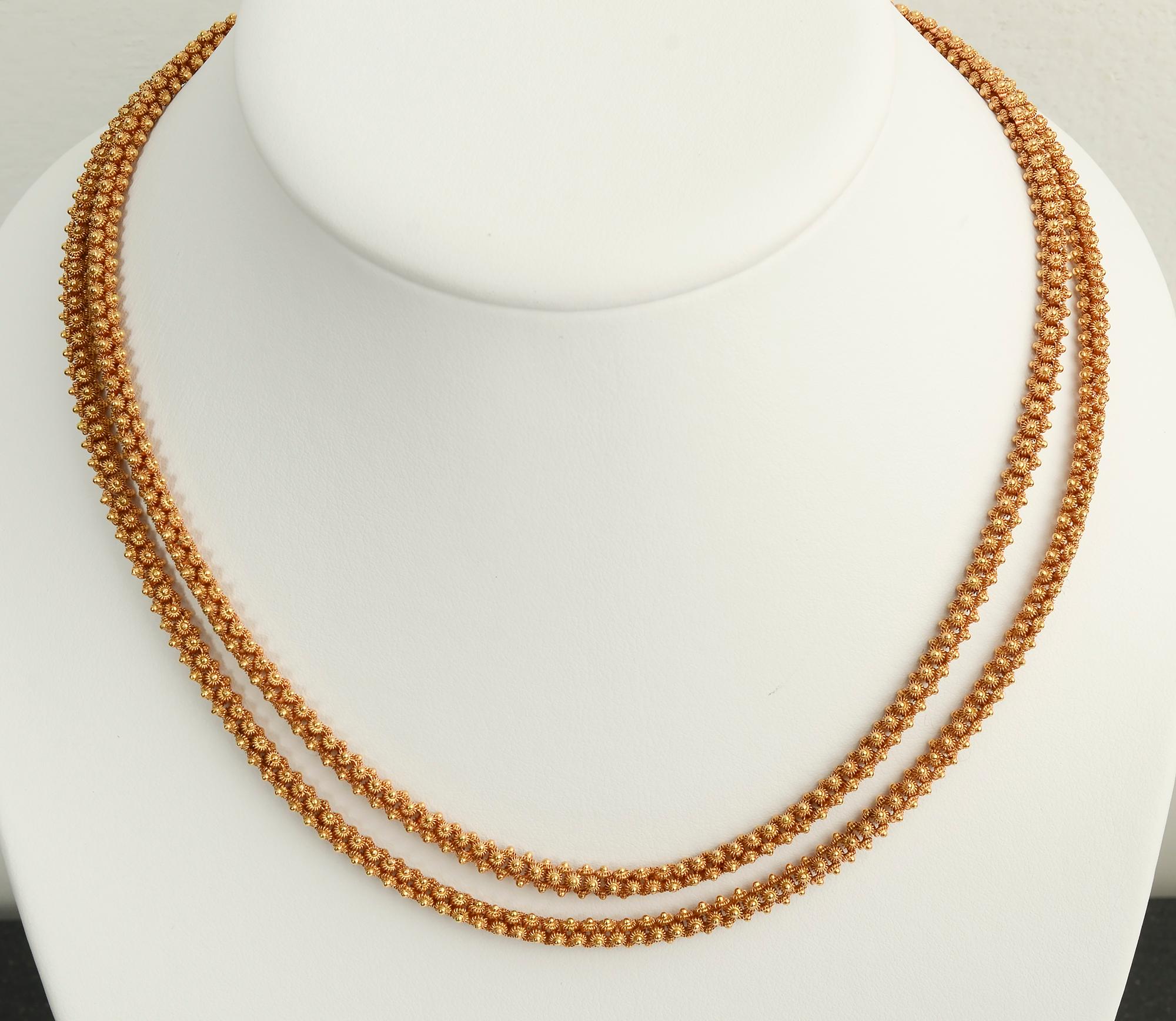 Extremely intricately made 18 karat long gold chain necklace. Each link consists of a tiny dome surrounded by curved spokes. Four of these elements make up a single link. The necklace is 36 inches long so it can comfortably be worn singly or doubled.