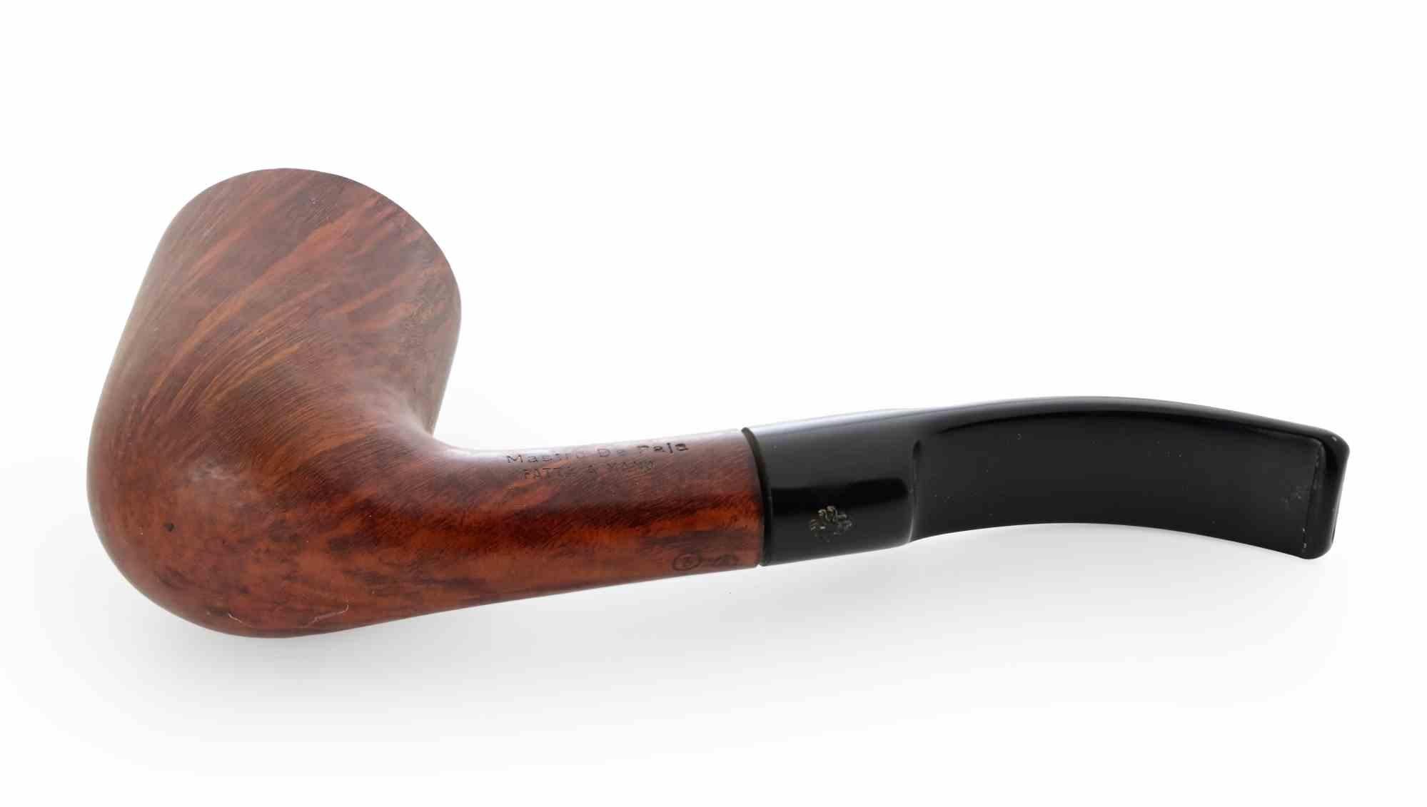 Pipe à fumer courbée Maestro De Paja fabriquée à la main, un classique de l'artisanat italien.

Le bol présente une finition chaude en bruyère brun-rouge, avec des veines droites et flammées visibles, mettant en valeur la beauté naturelle du bois.