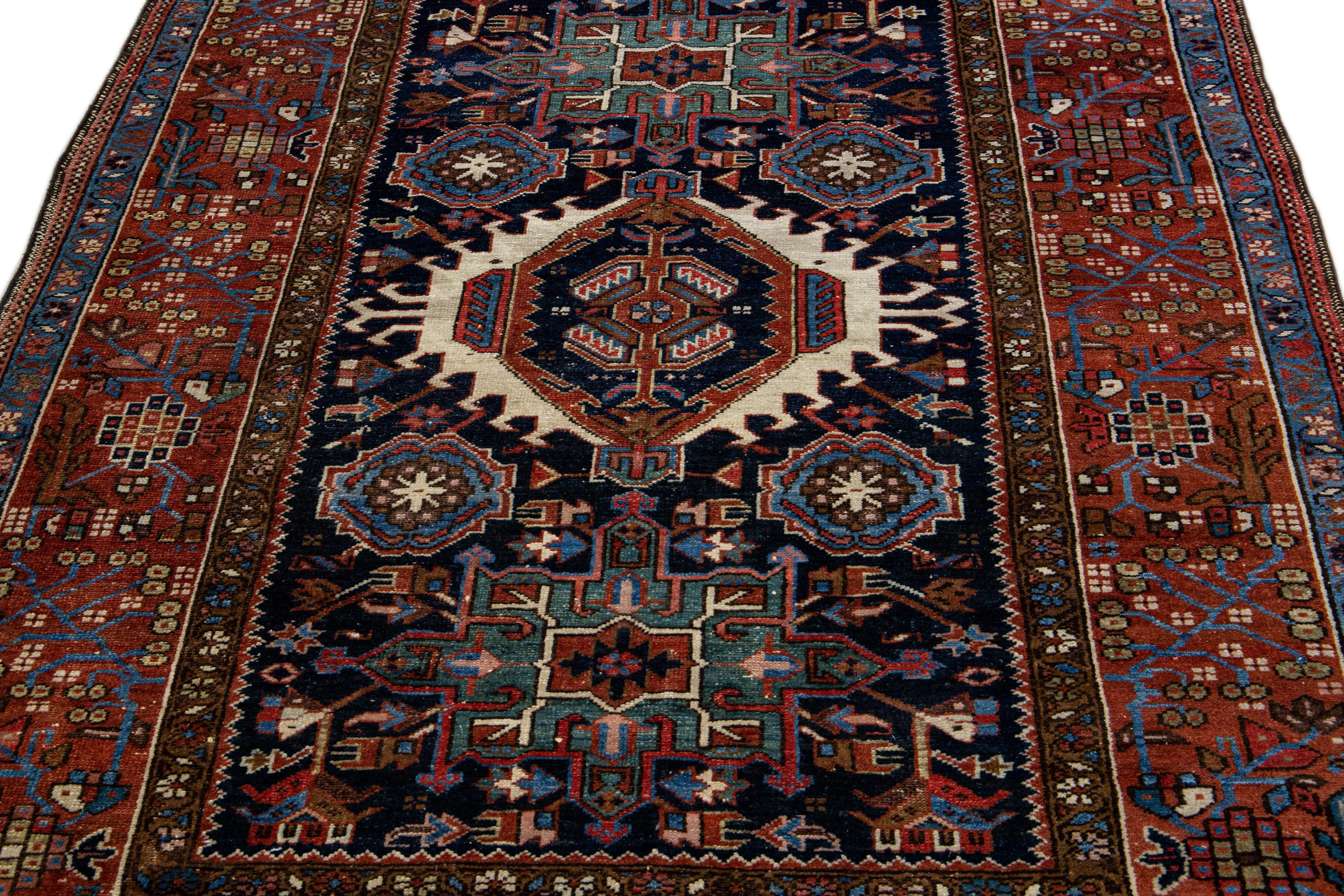Beautiful antique Heriz hand-knotted wool rug with a navy blue color field. This Persian rug has multicolor accents in a gorgeous all-over medallion floral motif.

This rug measures: 4'11