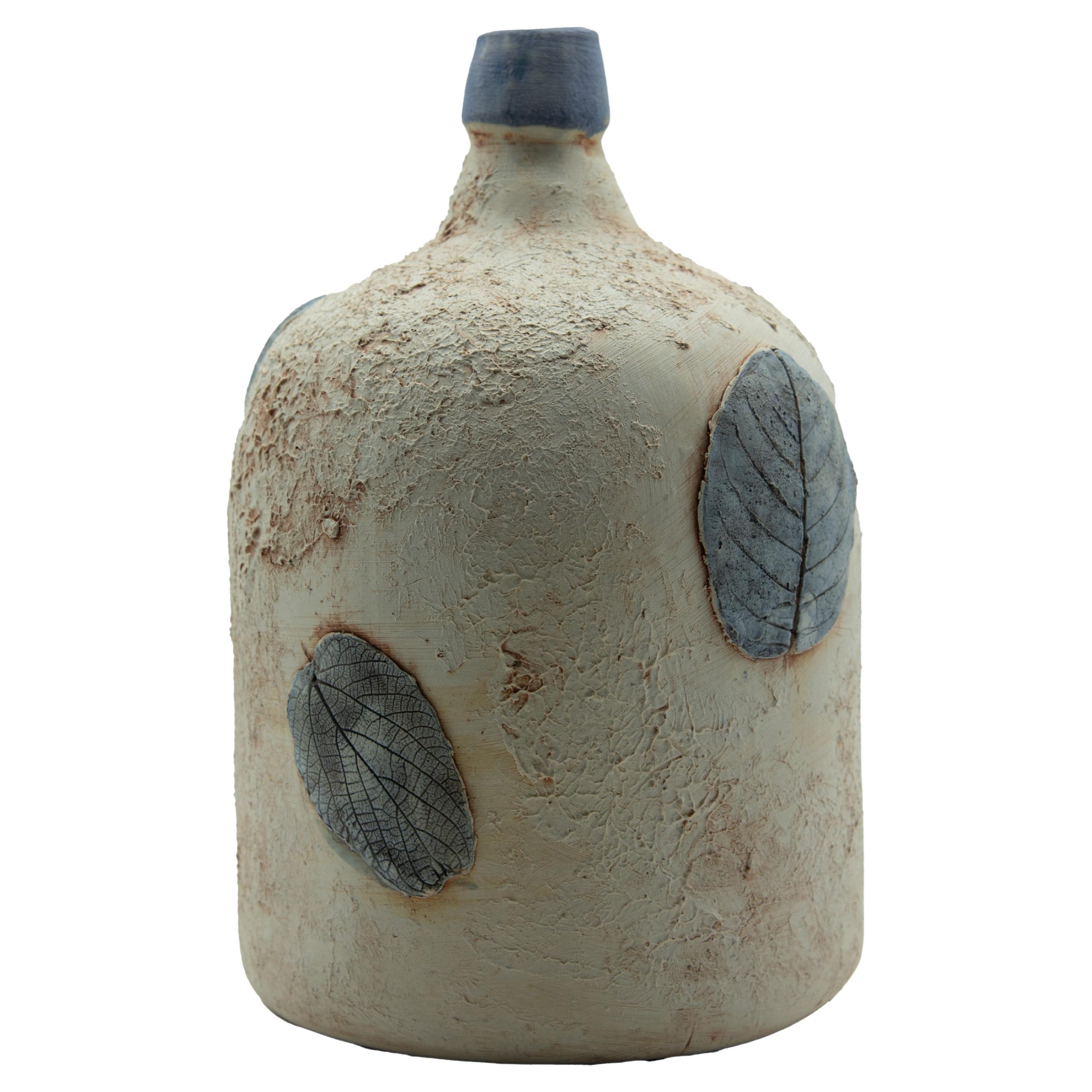 This rustic mezcal bottle is a replica of an antique bottle or demijohn which was used to store mezcal, drunken during folk theaters in Oaxaca, Mexico. The bottle is done with ceramic graffiti sgraffito technique which is later painted with oxide